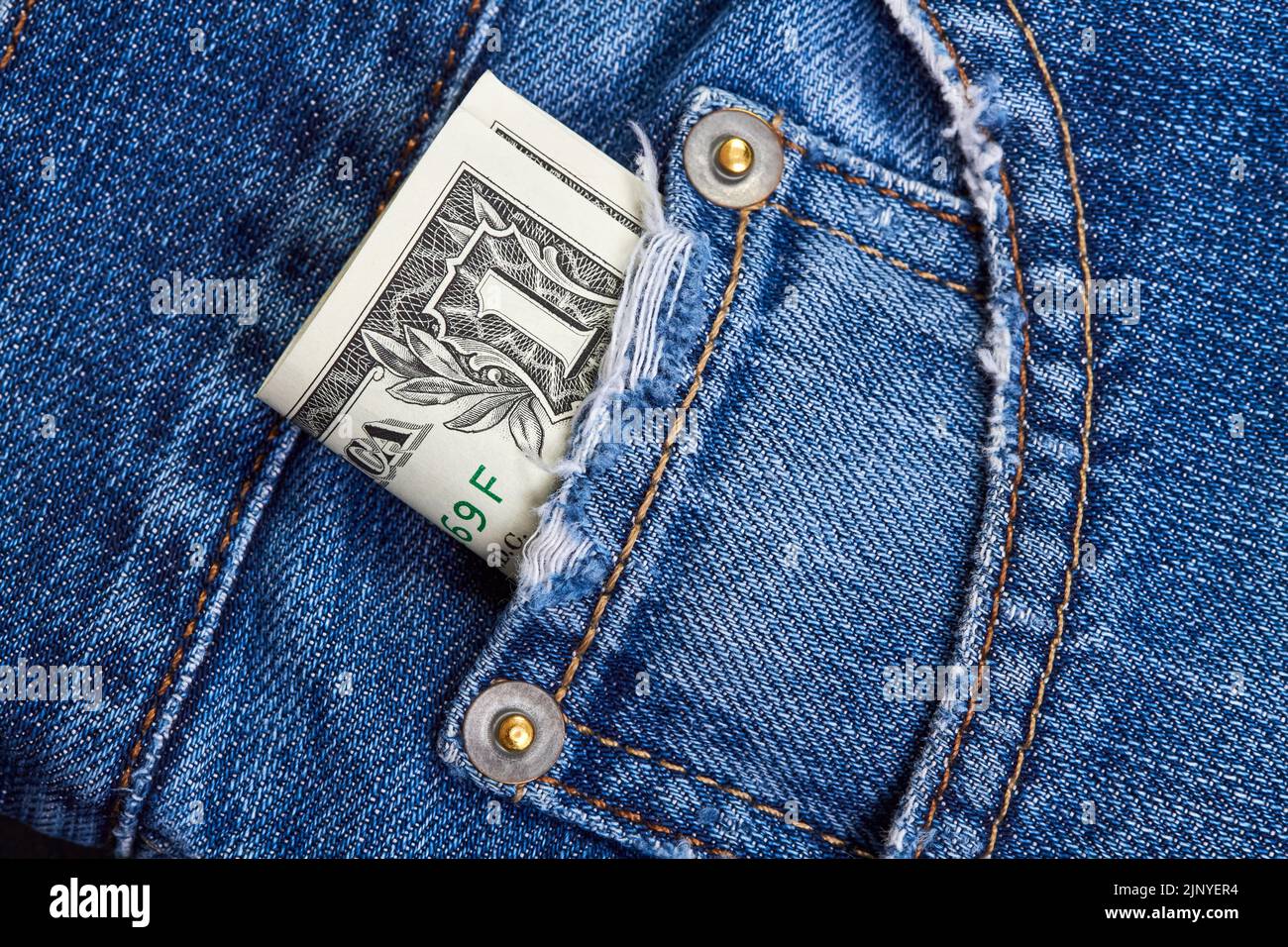 Arrotolato sulle fatture del dollaro in tasca dei jeans Foto Stock