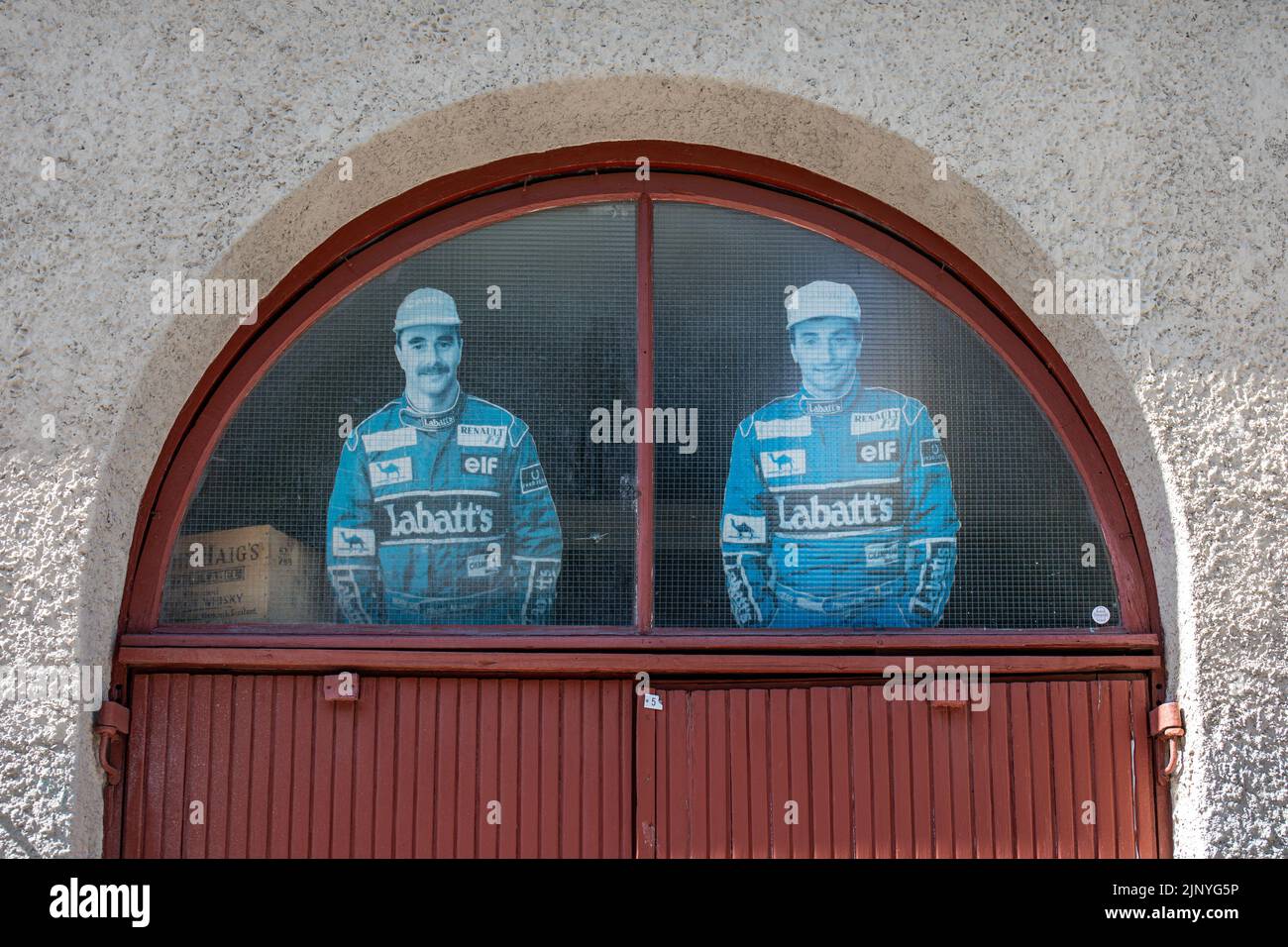 Nigel Mansell e Riccardo Patrese figure ritagliate in cartone nella finestra ad arco del garage di Helsinki, Finlandia Foto Stock