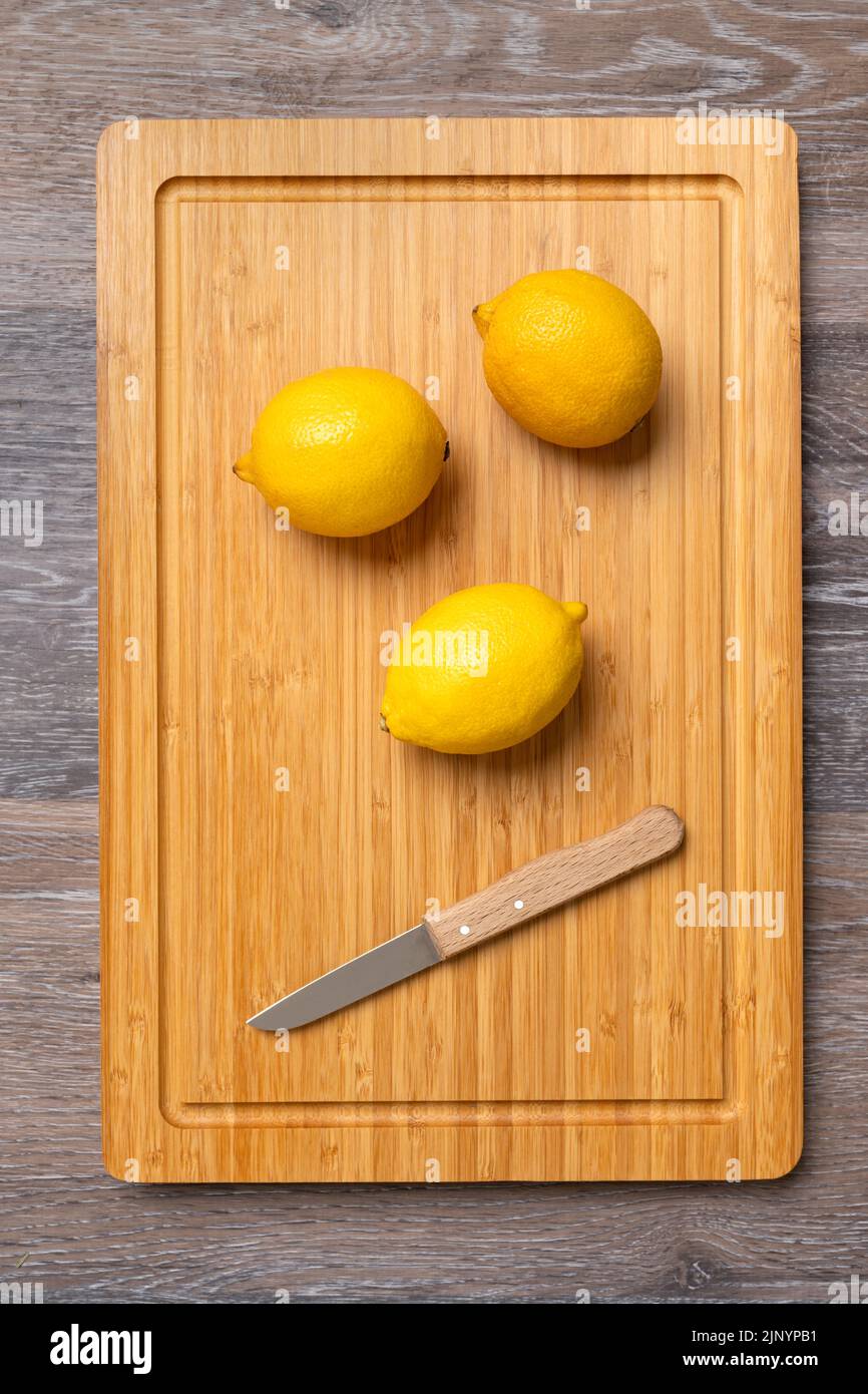 Tre limoni maturi su un tavolo da cucina, primo piano, prodotto ad alto contenuto di vitamina C. Foto Stock