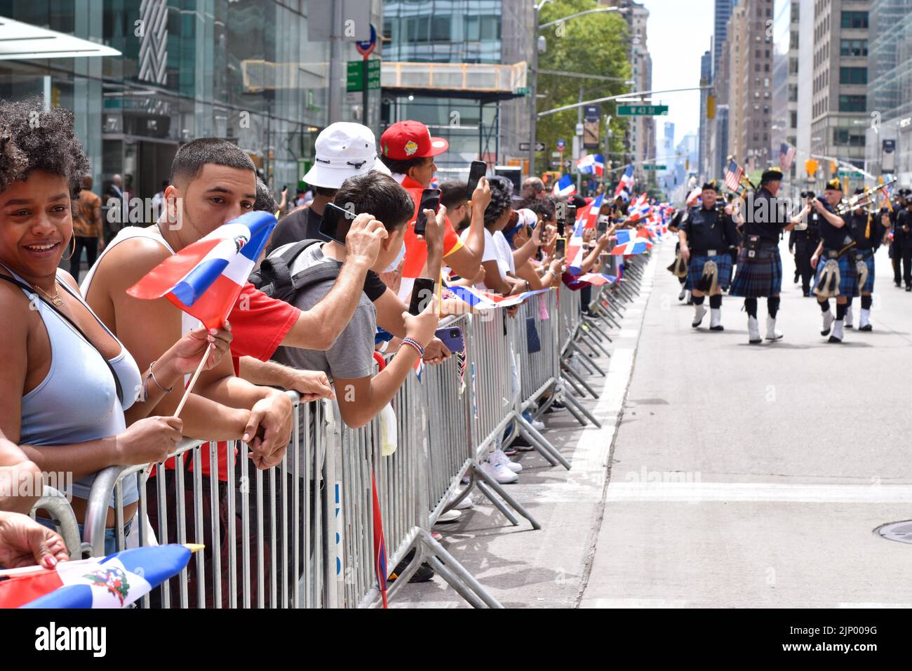 I newyorkesi dominicani sono visti sventolare bandiere durante la parata annuale del giorno domenicano lungo Avenue of the Americas a New York City il 14 agosto 2022. Foto Stock