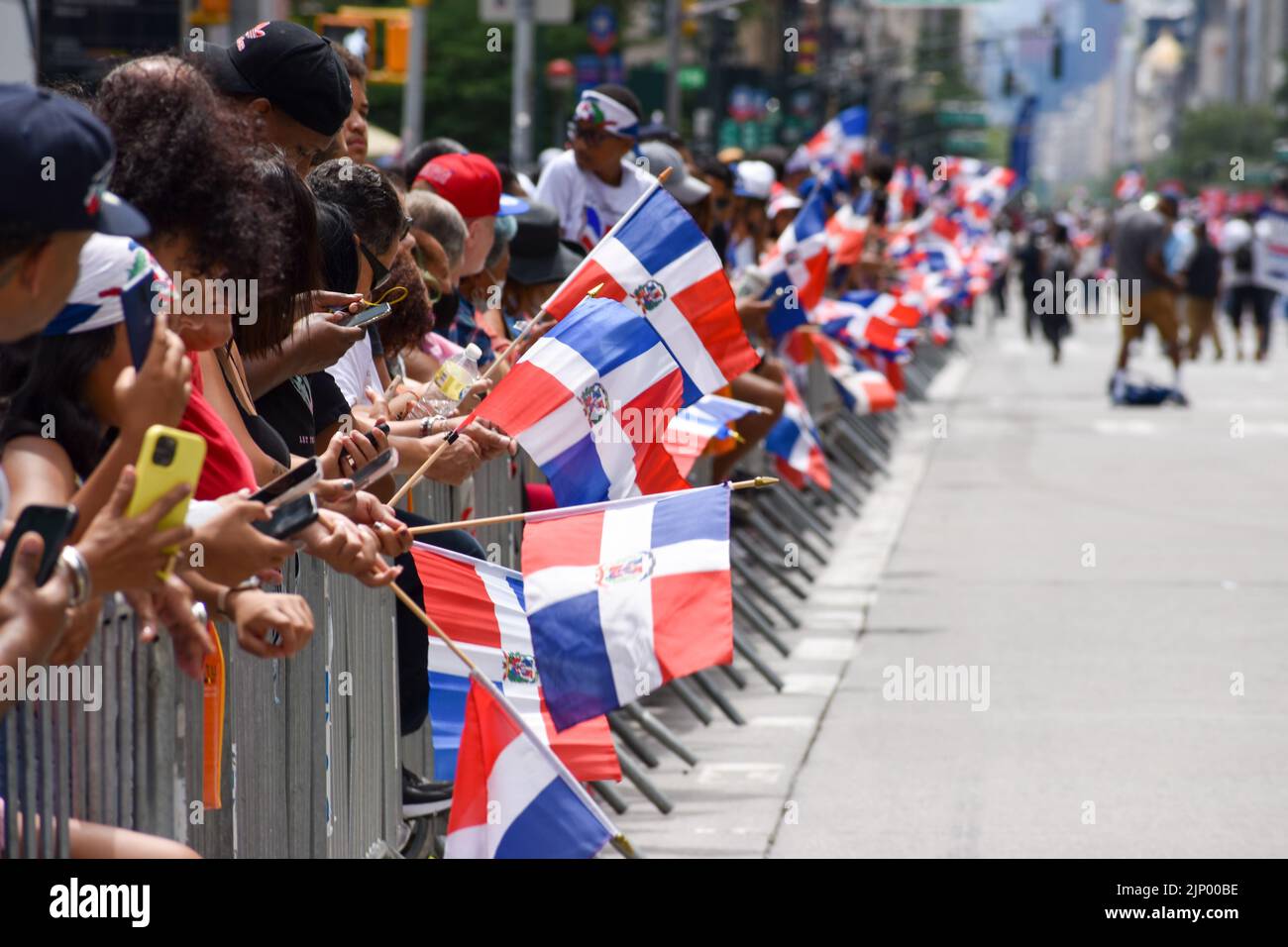 I newyorkesi dominicani sono visti sventolare bandiere durante la parata annuale del giorno domenicano lungo Avenue of the Americas a New York City il 14 agosto 2022. Foto Stock