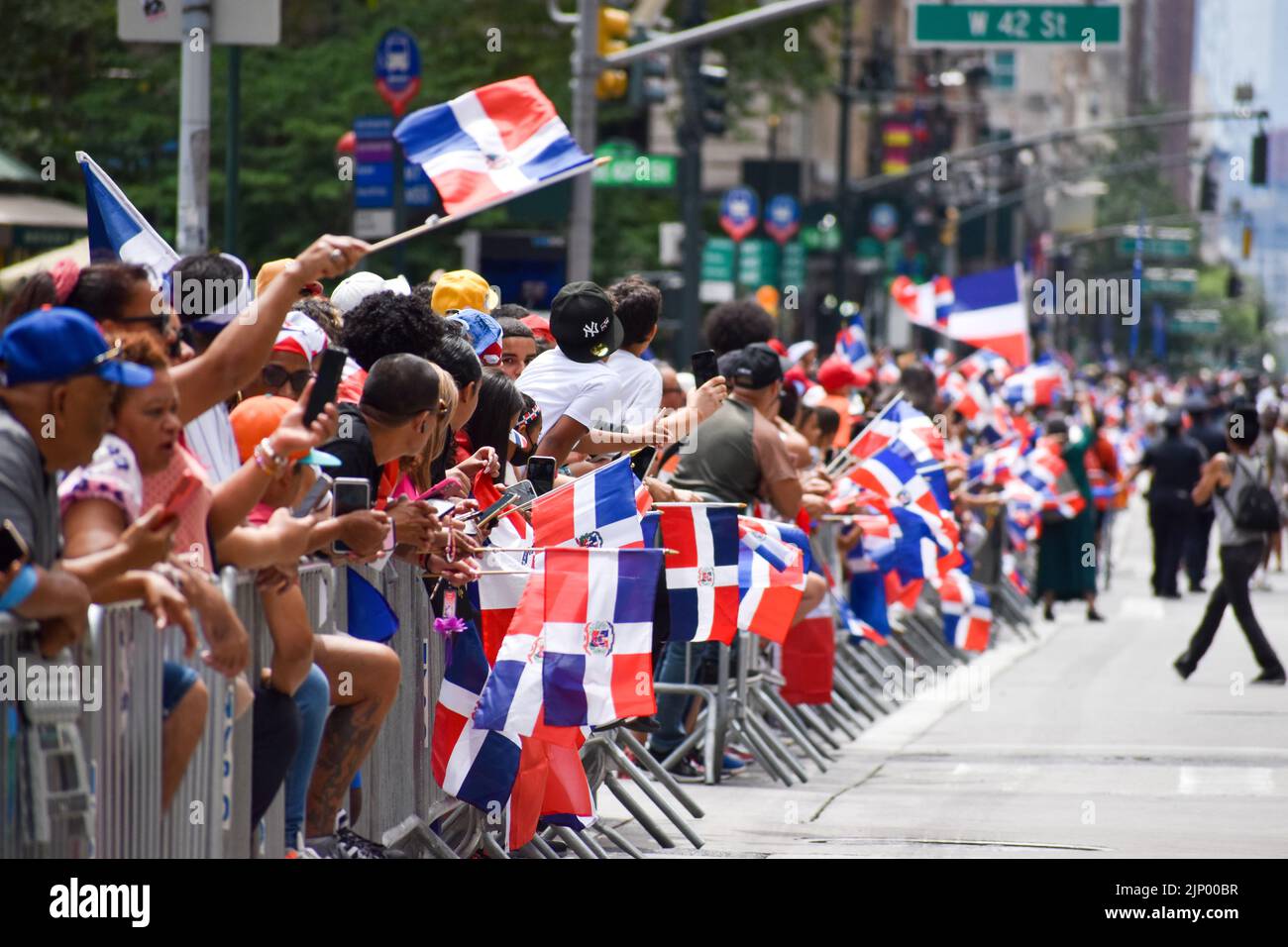 Migliaia di persone sono viste sventolando bandiere durante la parata annuale del giorno Domenicano lungo Avenue of the Americas a New York City il 14 agosto 2022. Foto Stock