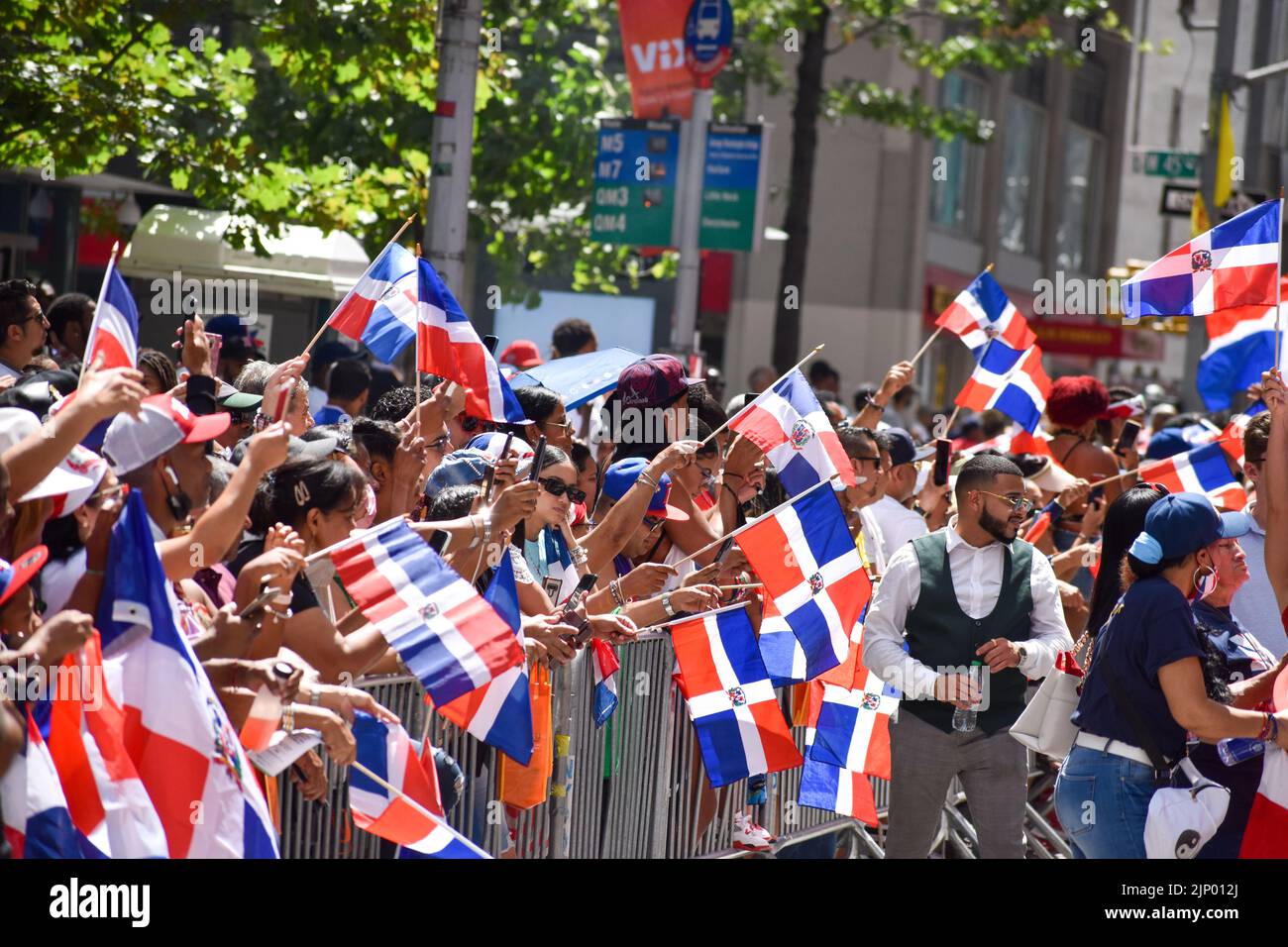 I newyorkesi di tutte le età sono visti indossare la bandiera dominicana durante la parata del giorno domenicano sulla Sixth Avenue a New York City. Foto Stock