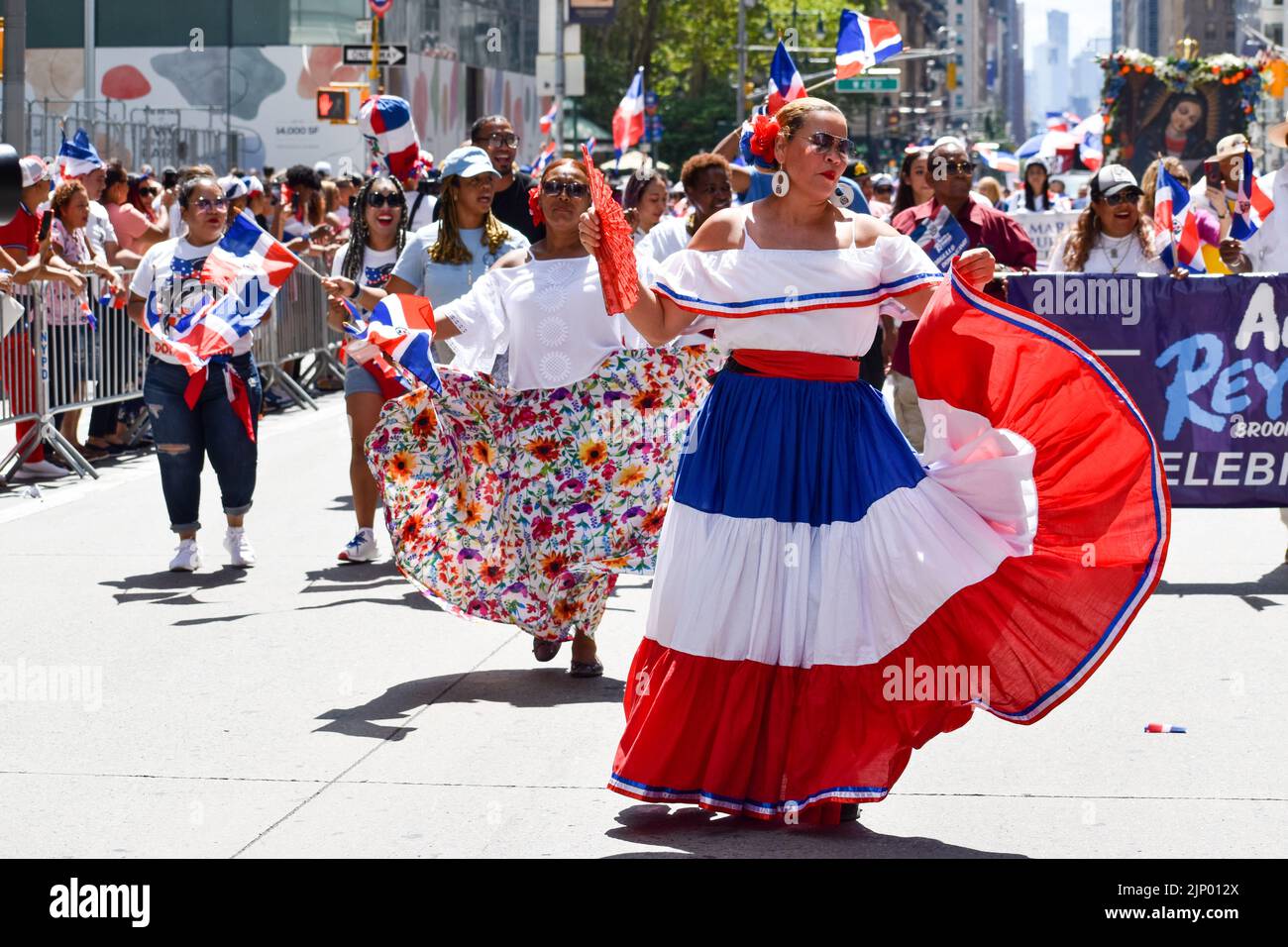 Un partecipante indossa un abito tradizionale, ballando durante la Giornata Dominicana Parata sulla Sesta Avenue a New York City. Foto Stock