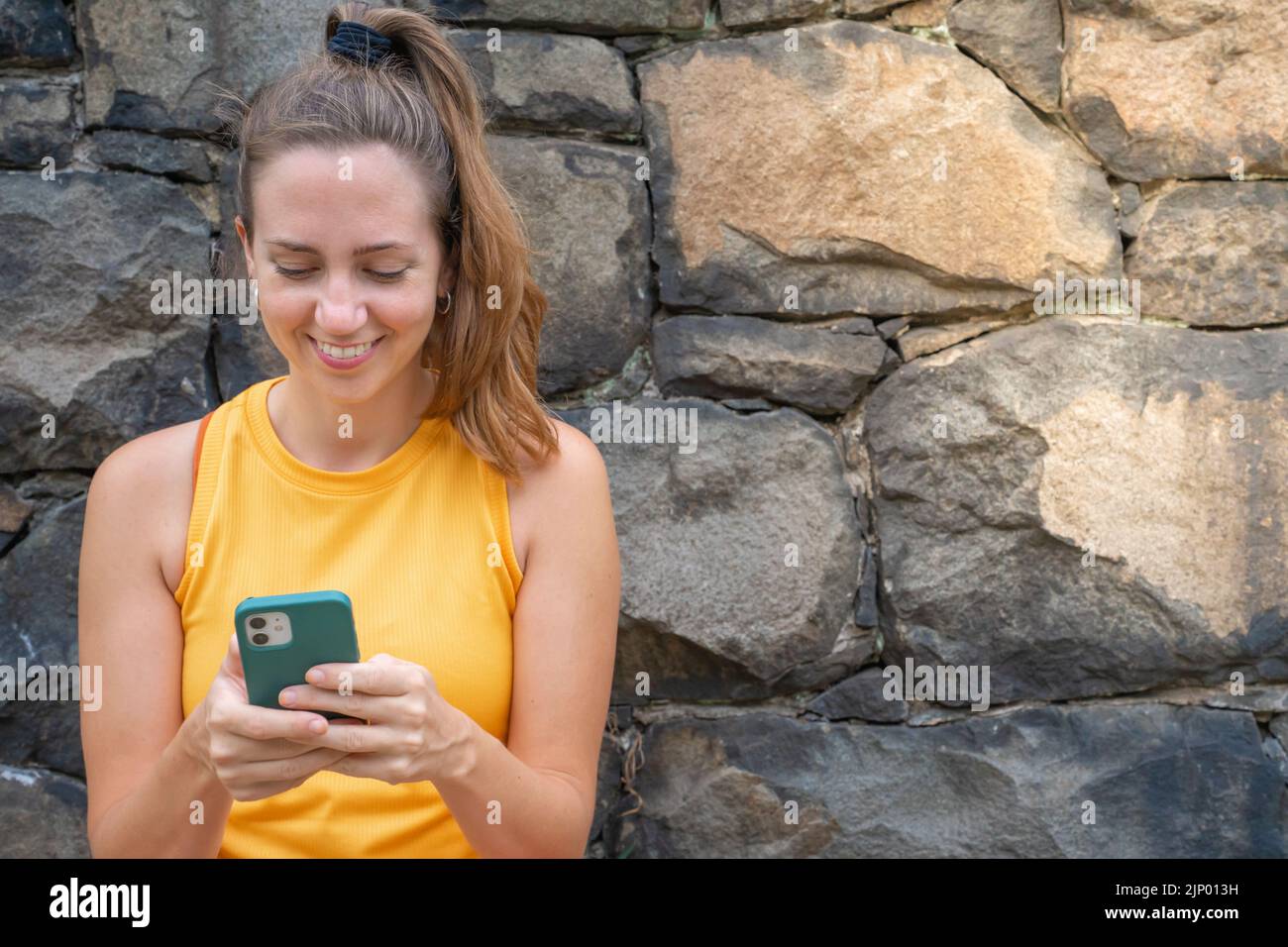Atleta giovane e attraente che tiene il suo telefono cellulare in preparazione per l'esercizio. Foto Stock