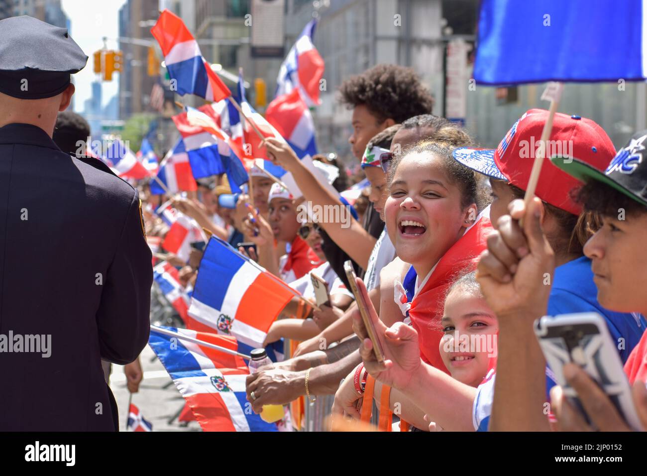 I newyorkesi di tutte le età sono visti indossare la bandiera dominicana durante la parata del giorno domenicano sulla Sixth Avenue a New York City. Foto Stock