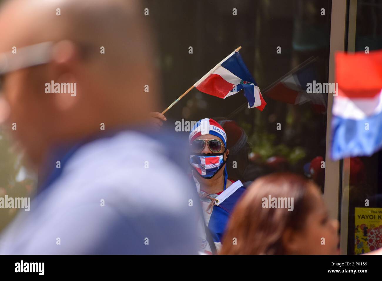 Un partecipante indossa la bandiera dominicana durante la parata del giorno dominicano sulla Sixth Avenue a New York City. Foto Stock