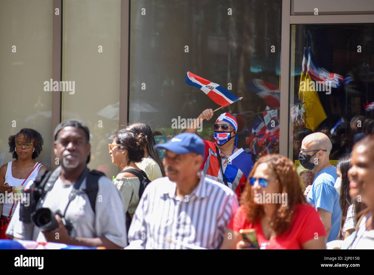 Un partecipante indossa la bandiera dominicana durante la parata del giorno dominicano sulla Sixth Avenue a New York City. Foto Stock