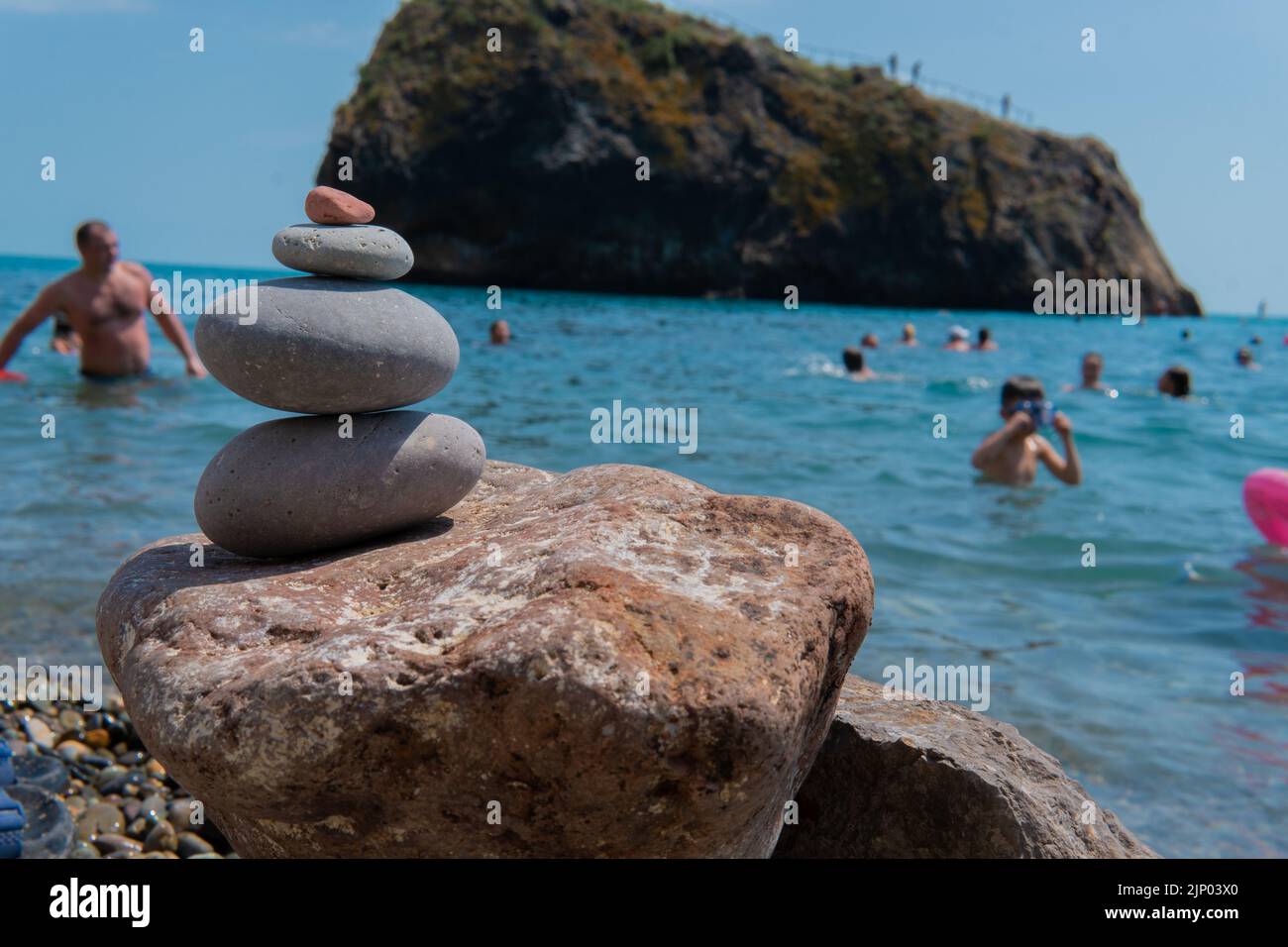 Meditazione spiaggia piramide equilibrio zen mare pietre estate costa grigio, concetto natura spa da sfondo paesaggio e roccia, viaggio spirituale. Ghiaia Foto Stock