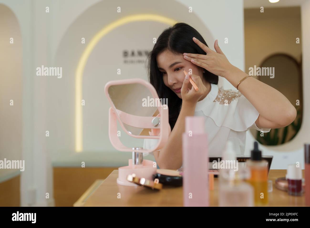 Donna usando cosmetic e provi a fare in su dopo il suo vlogger Foto Stock