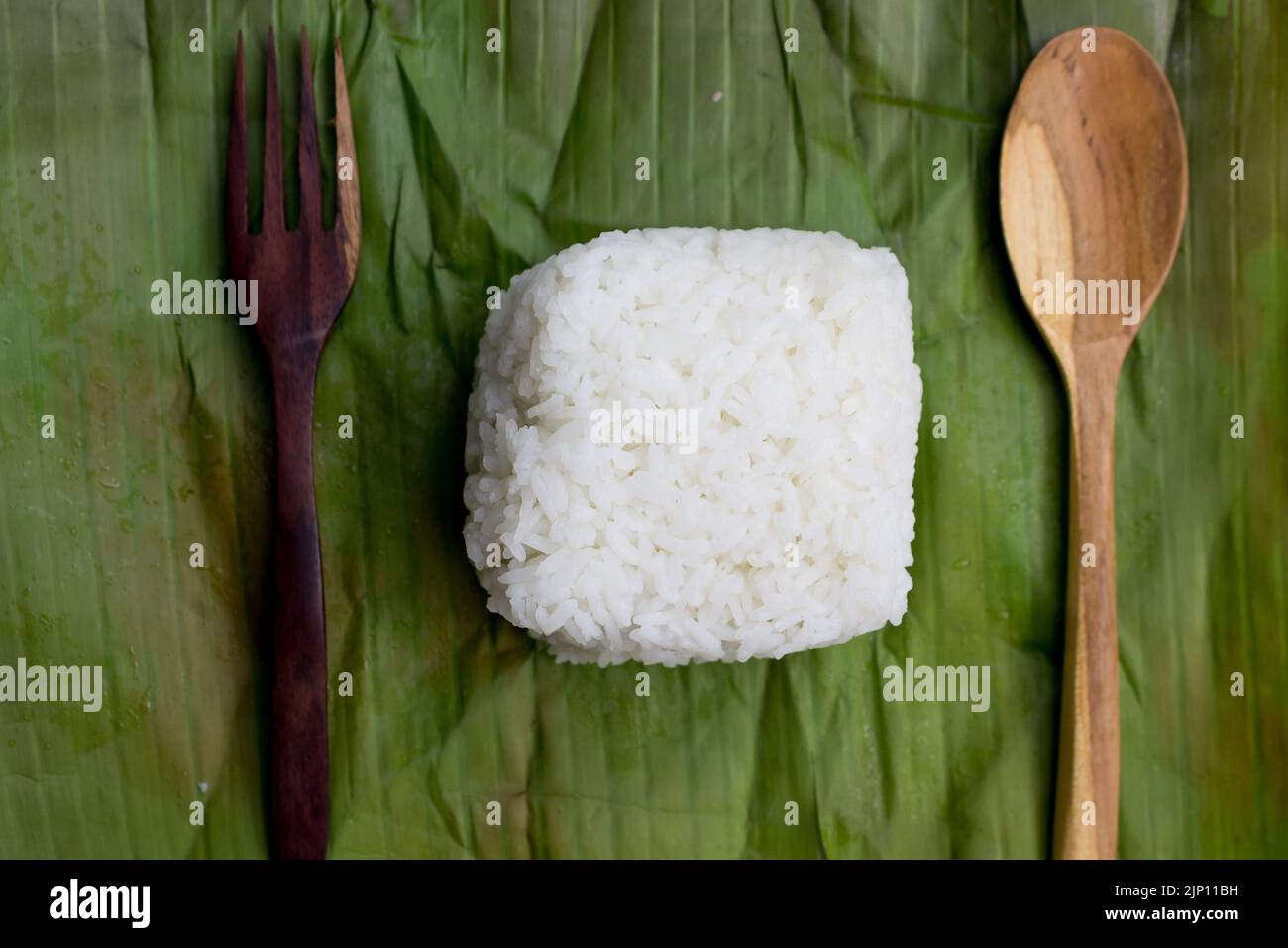 Nasi timbel indonesiano o riso bianco al vapore avvolto in foglia di banana Foto Stock