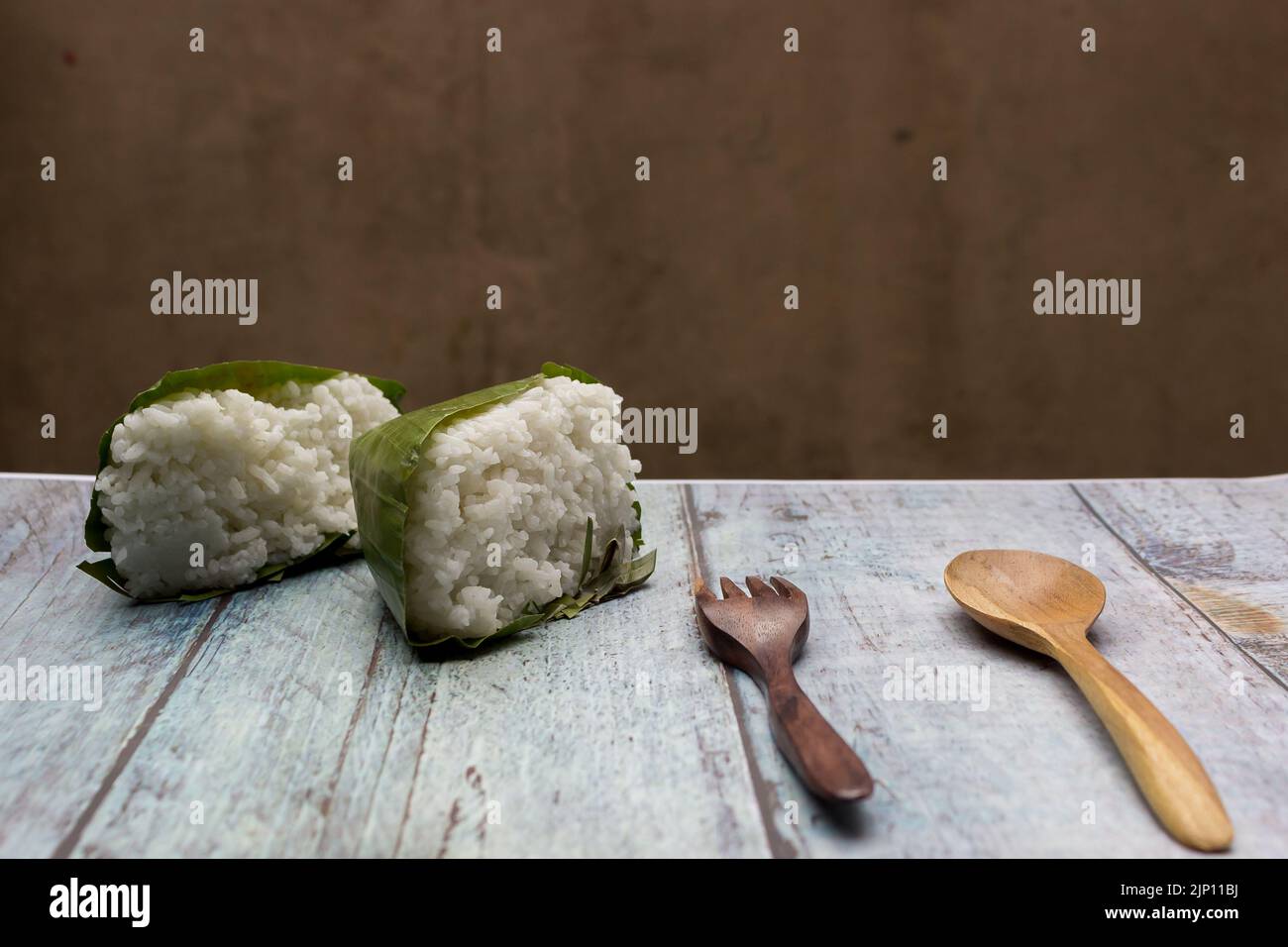 Nasi timbel indonesiano o riso bianco al vapore avvolto in foglia di banana Foto Stock
