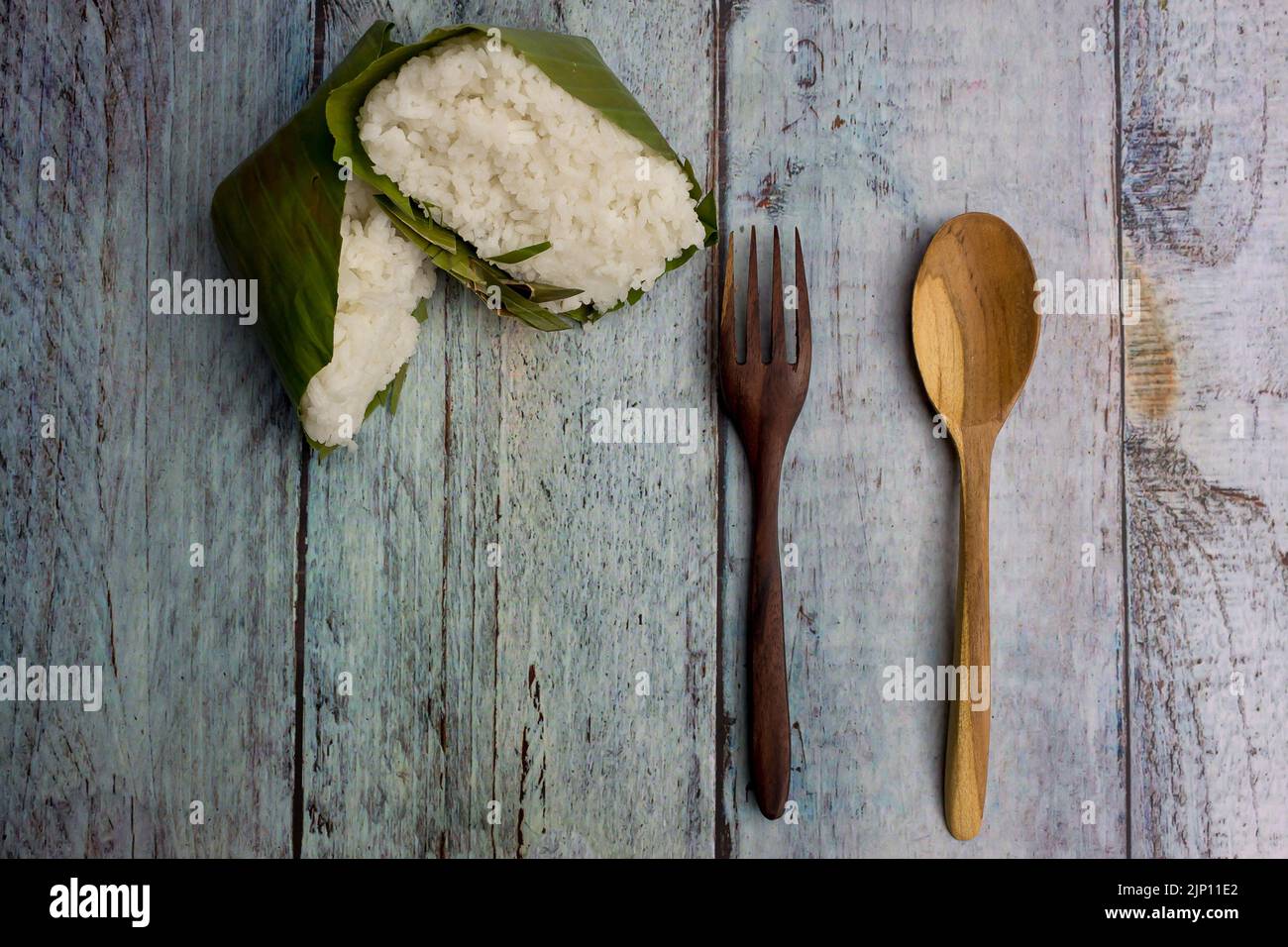 Nasi timbel indonesiano o riso bianco al vapore avvolto in foglia di banana Foto Stock