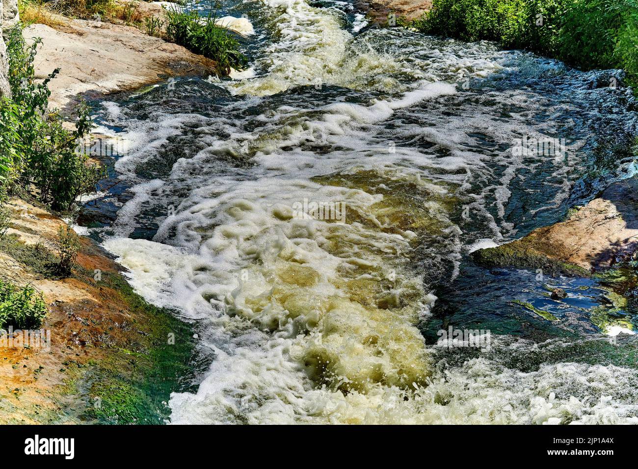 Flusso d'acqua puro e potente di un fiume di montagna in una giornata di sole caldo Foto Stock
