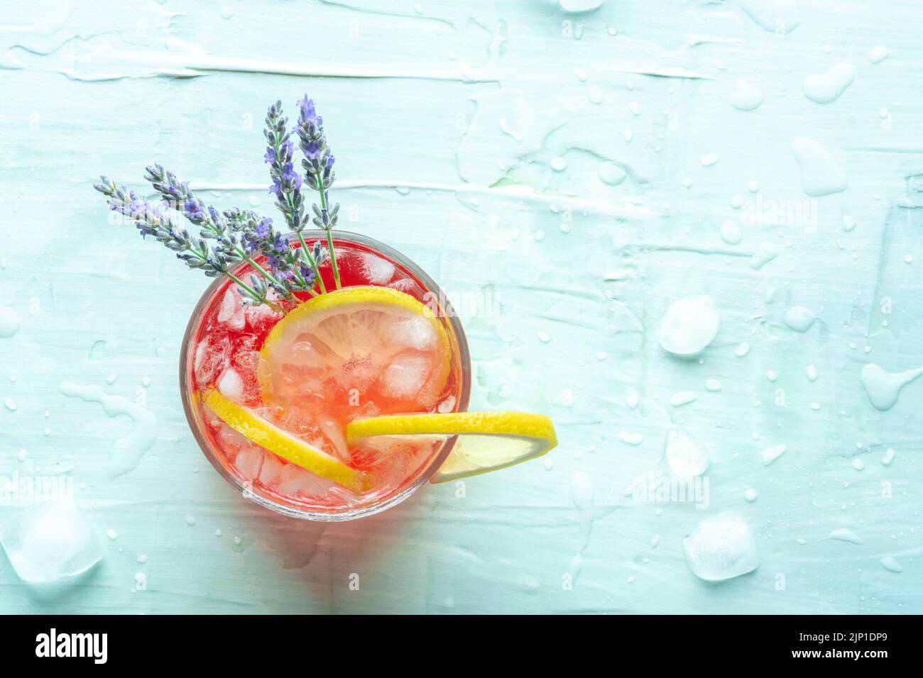Cocktail estivo fresco o coda di mocktail con limone e lavanda, una bevanda fredda agli agrumi con ghiaccio, top shot su sfondo blu con spazio copia Foto Stock