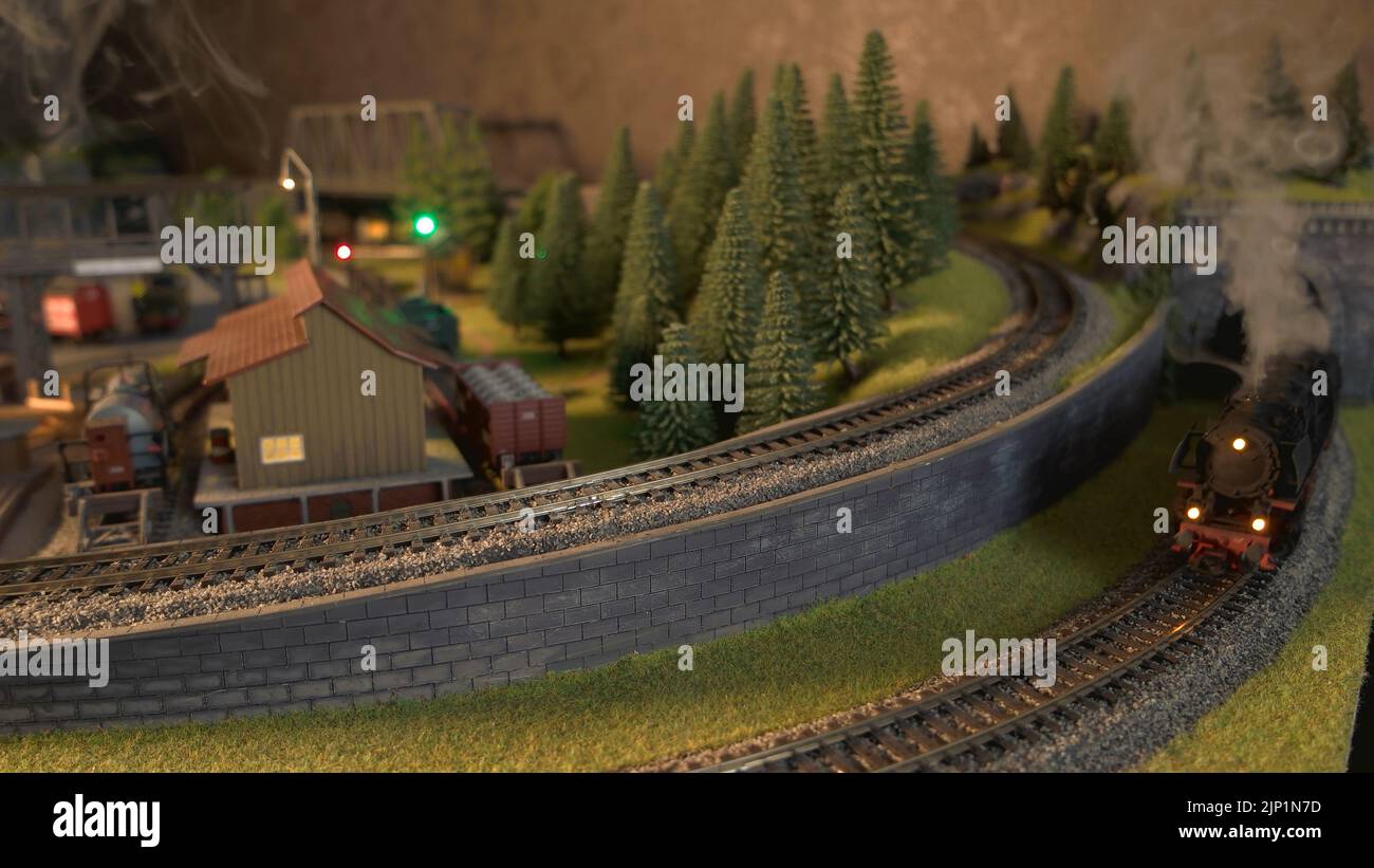 Locomotive a vapore che corrono su un modello di ferrovia. Treni passeggeri e merci che attraversano la stazione ferroviaria in miniatura. Foto Stock