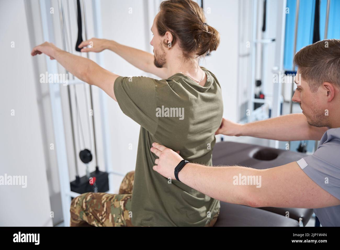 L'uomo militare subisce una sessione di esercizi di fisioterapia Foto Stock