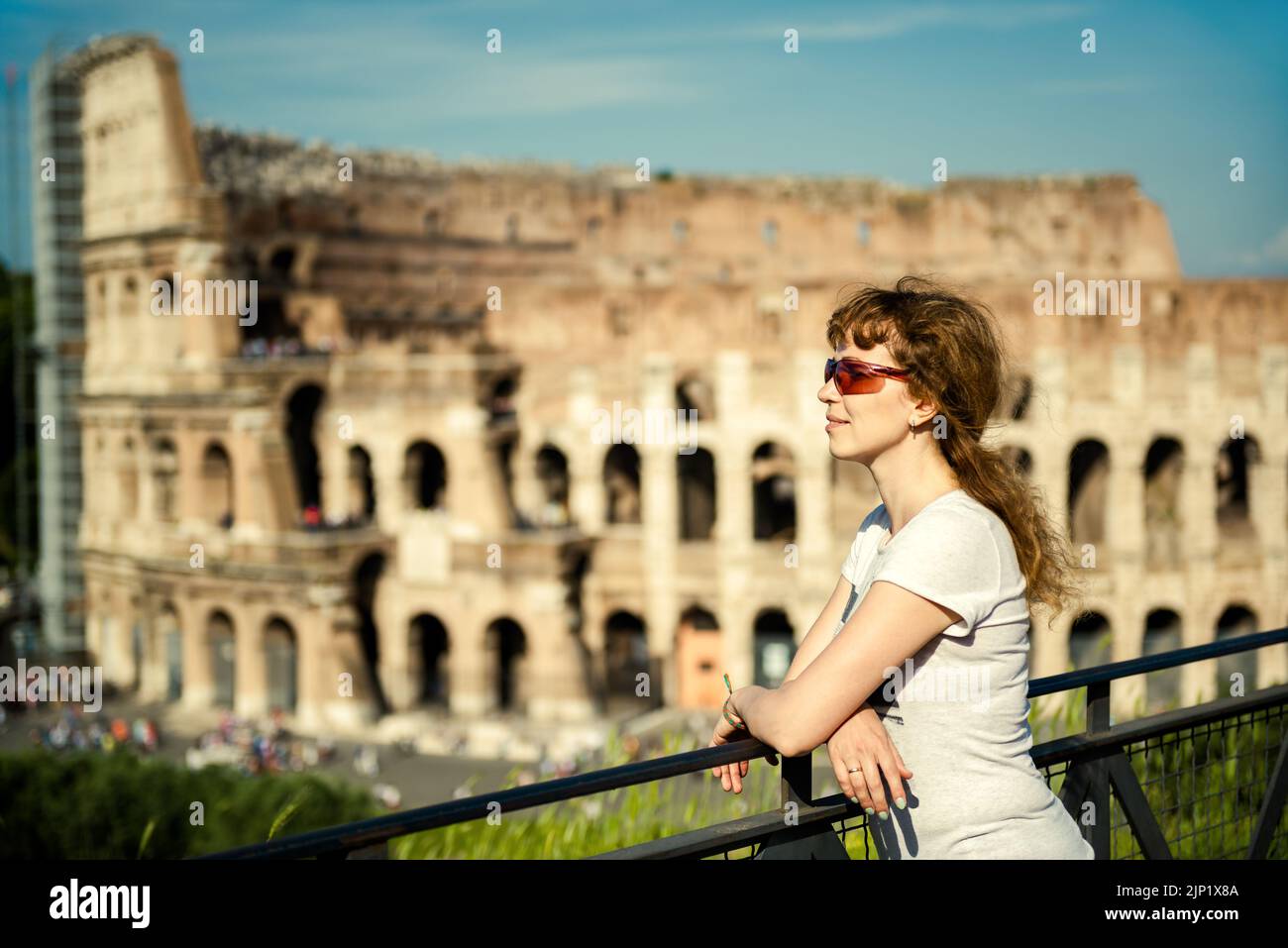Giovane donna turistica su sfondo Colosseo, Roma, Italia. Una bella ragazza adulta visita il famoso Colosseo, punto di riferimento italiano. Concetto di gente di viaggio, vacati Foto Stock
