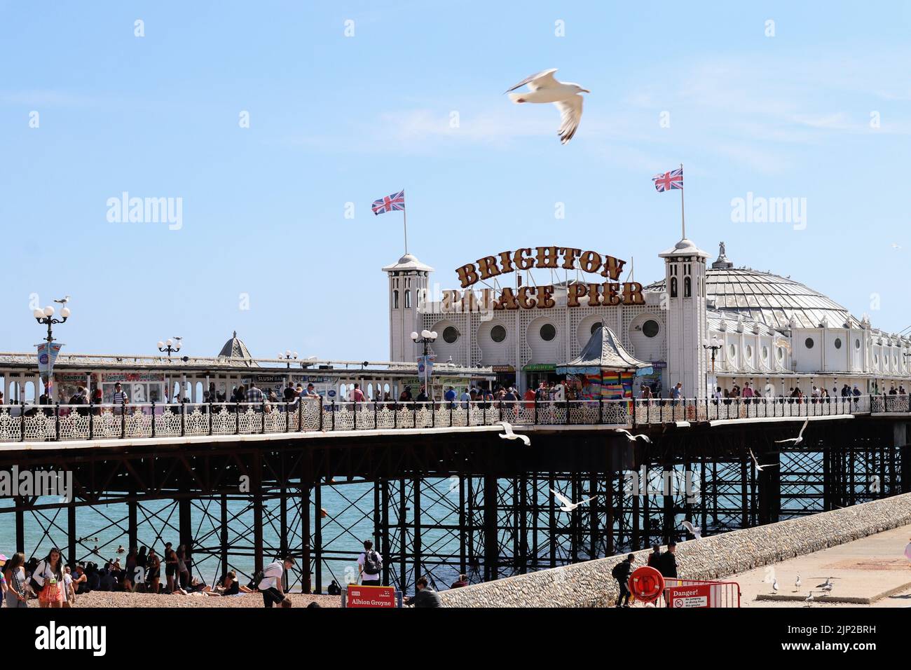 La gente si gode la spiaggia vicino al Brighton Palace Pier Foto Stock