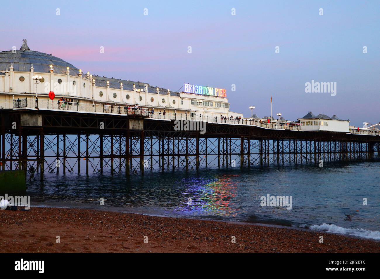 Il Brighton Palace Pier con il suo logo illuminato dall'arcobaleno Foto Stock