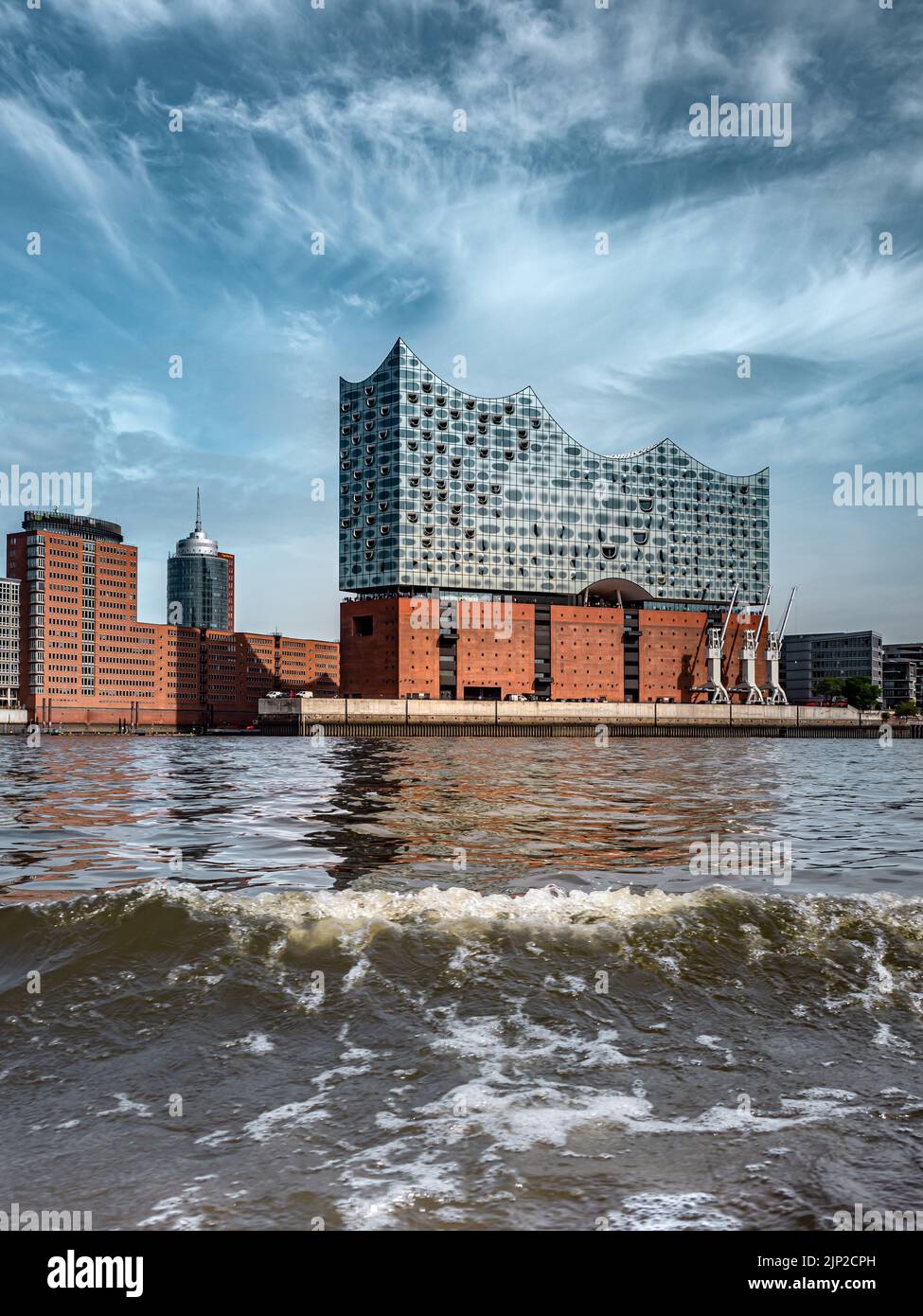 Uno scatto verticale della sala concerti di Amburgo con il fiume Elba che scorre di fronte ad essa, Germania Foto Stock