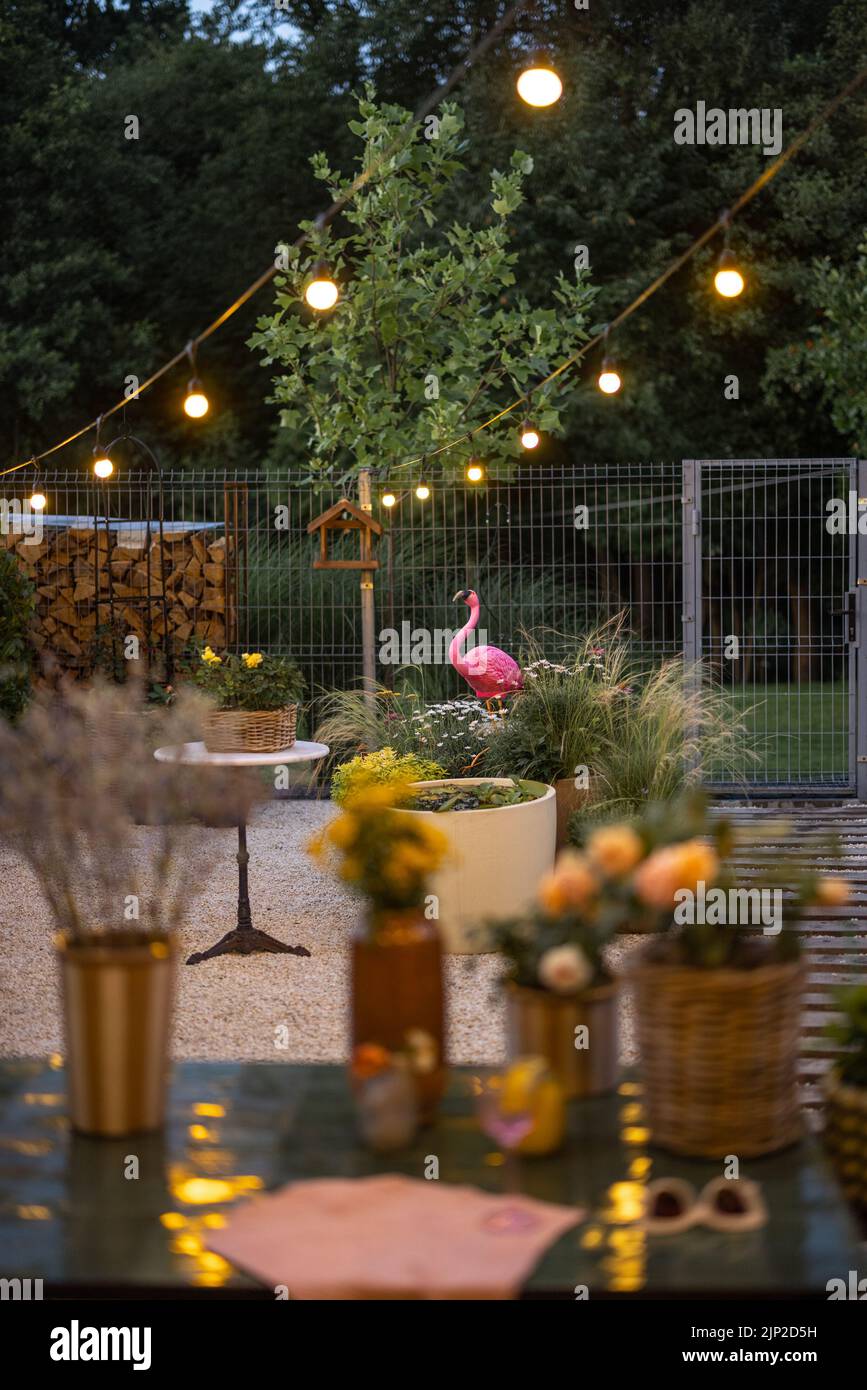 Cortile accogliente con fiori al crepuscolo Foto Stock