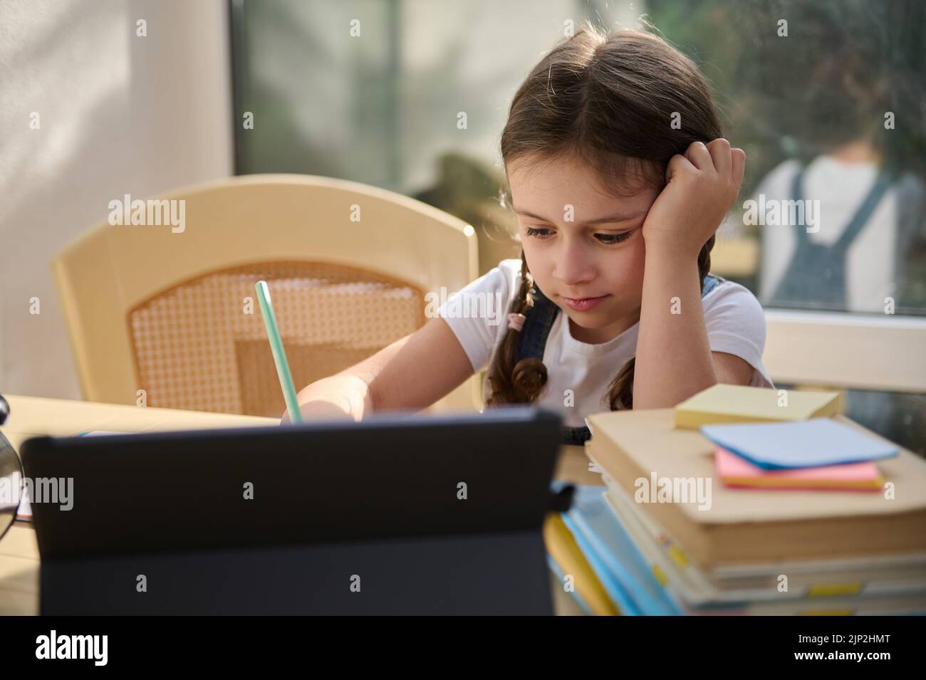 Affascinante seria studia a distanza, impara a scrivere lezioni, guarda corsi di lingua online su un gadget digitale Foto Stock