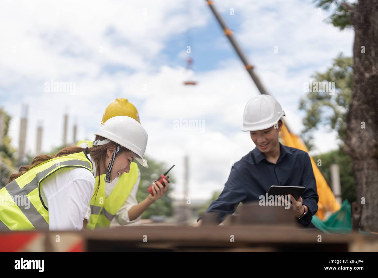 Giovani ingegneri edili che lavorano insieme nel cantiere background, concetto di ingegneria industriale Foto Stock