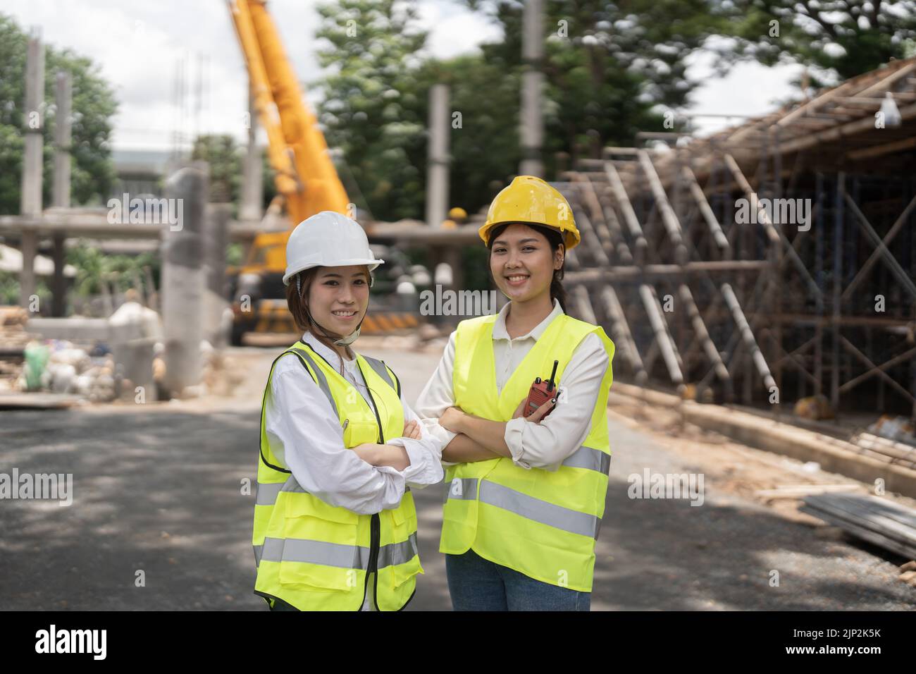 Ritratto due ingegnere asiatico donna costruzione appaltatori in piedi in cantiere, Foto Stock