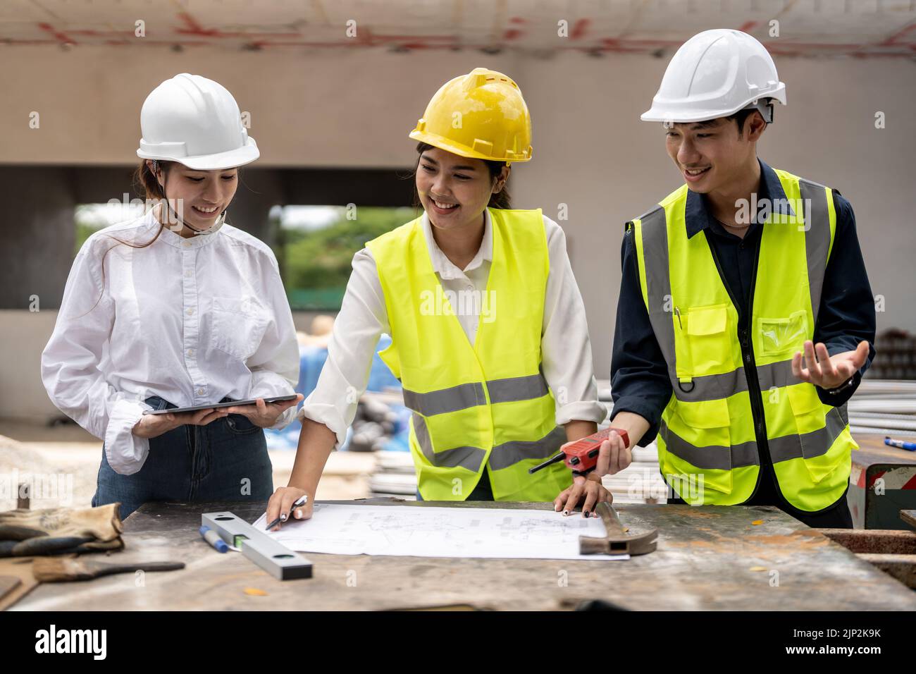 Caposquadra e ingegnere asiatico che si riunono in casa in costruzione Foto Stock