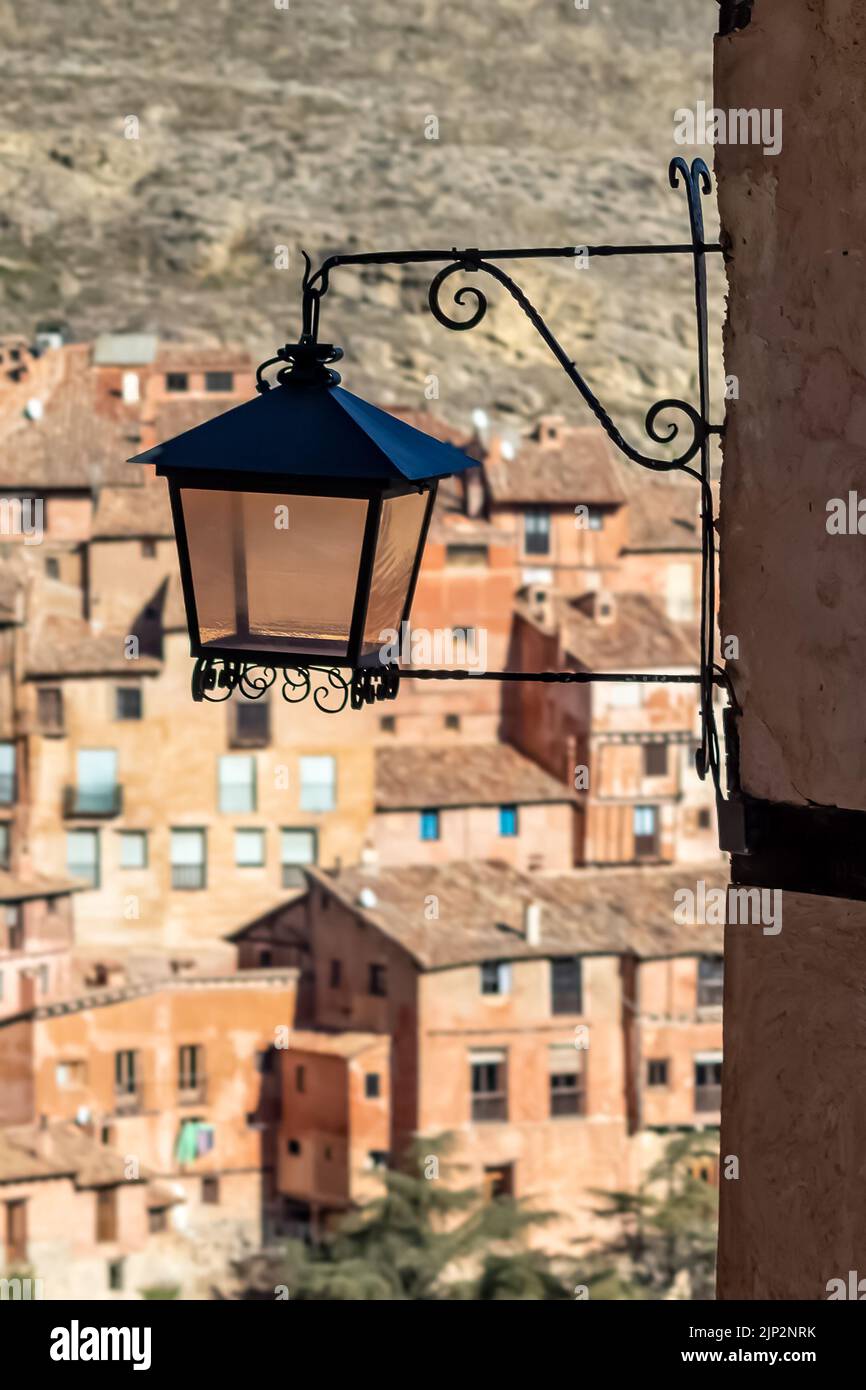 Vecchia lanterna su muro sullo sfondo del villaggio con vecchie case di pietra. Albarracin Spagna. Foto Stock