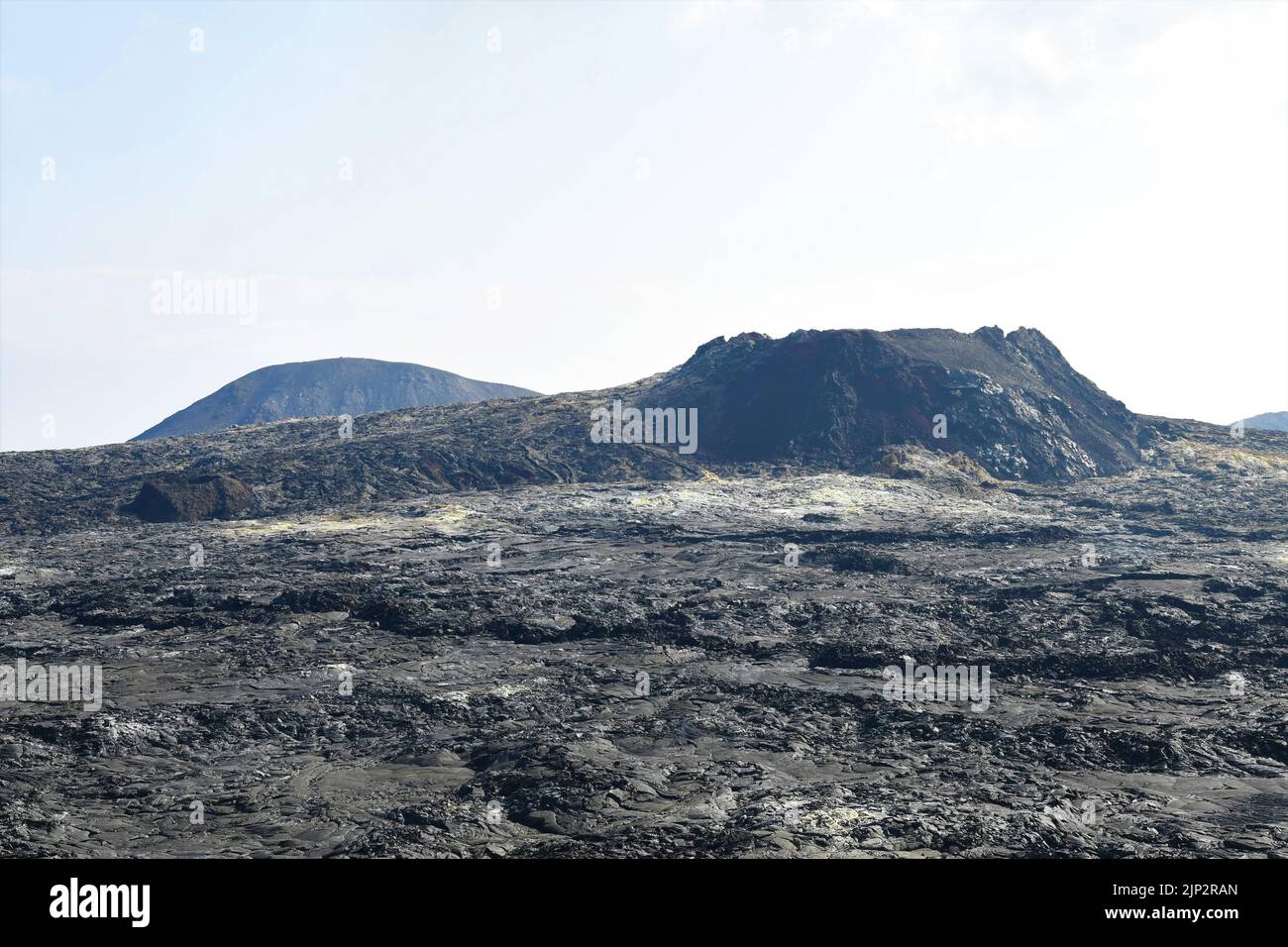 Lo sfiato del vulcano dall'eruzione del Fagradalfjall 2021, l'Islanda, presa un anno più tardi. Depositi minerali di zolfo possono essere visti sul campo lavico di fronte. Foto Stock