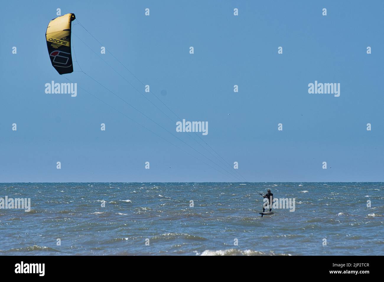 Un kitesurfer nelle acque tranquille della spiaggia di Scheveningen nei Paesi Bassi Foto Stock
