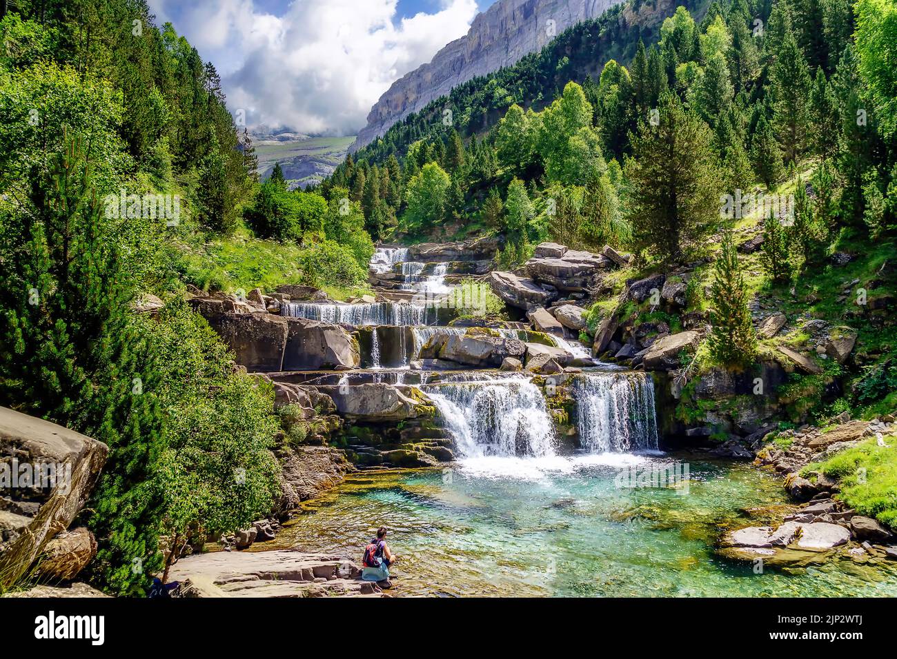 Cascata su gradini o terrazze in verde paesaggio tra alberi e montagne in Ordesa. Soaso si alza. Foto Stock