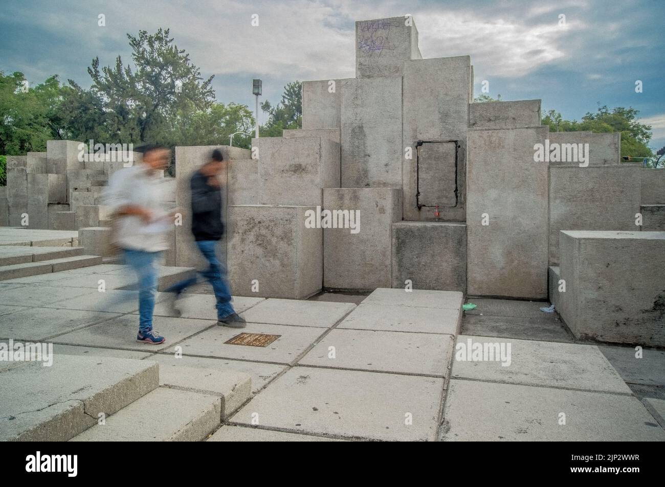 due persone che camminano, lunga esposizione sfocata, in pietra di sfondo scultura diversi livelli Foto Stock