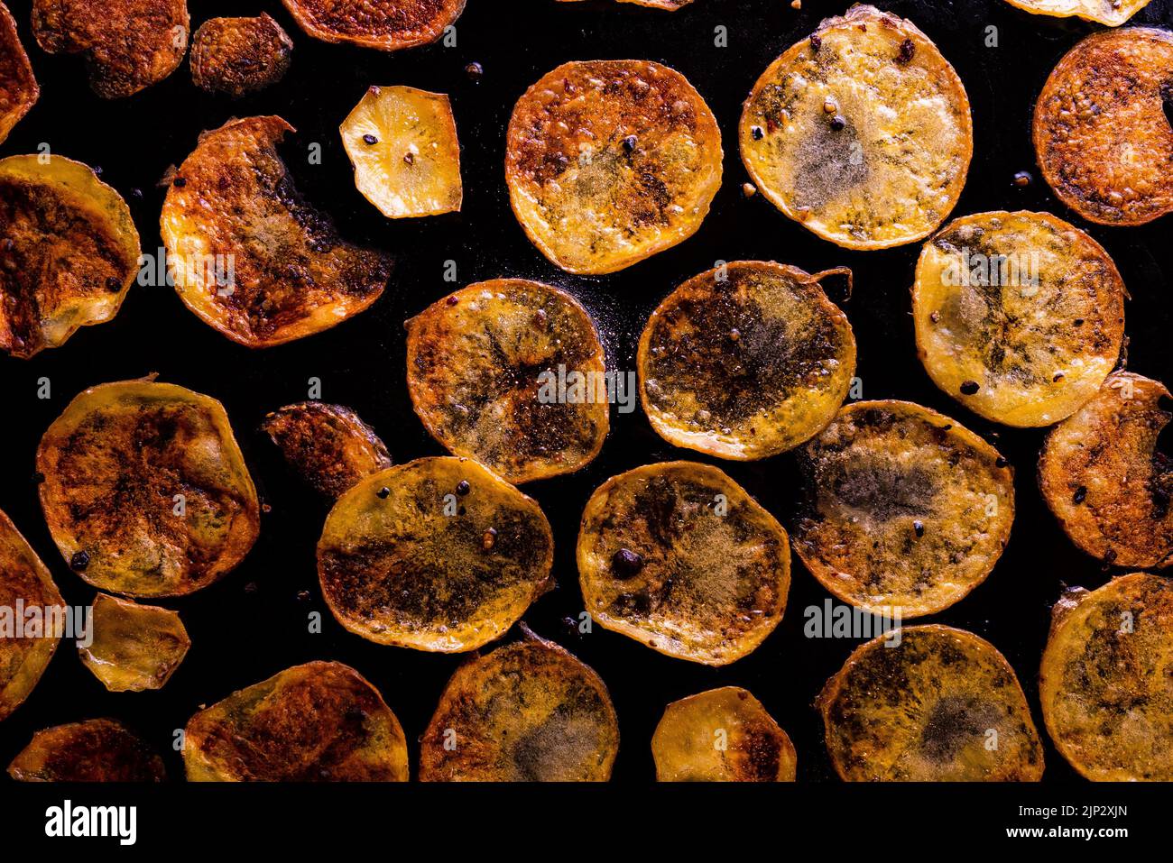 Vista dall'alto delle fette di patate rotonde che friggano su una padella oleosa Foto Stock