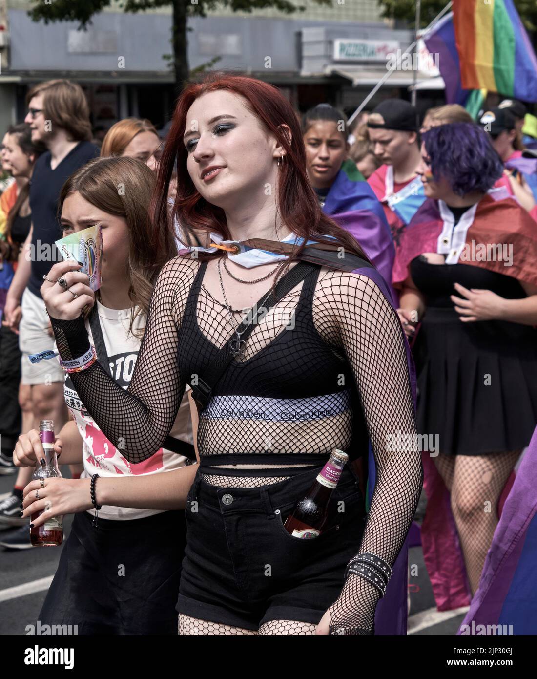 Braunschweig, Germania, 13 agosto 2022: Dimostratore con reggiseno nero, hottants, tuta di rete di pesce e una bottiglia di birra nei suoi pantaloni alla sfilata CSD Foto Stock