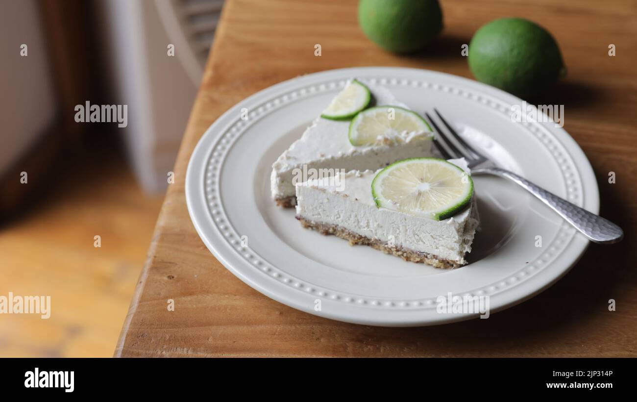 Un delizioso piatto di cremose crostate di lime ricoperte di fettine di lime Foto Stock