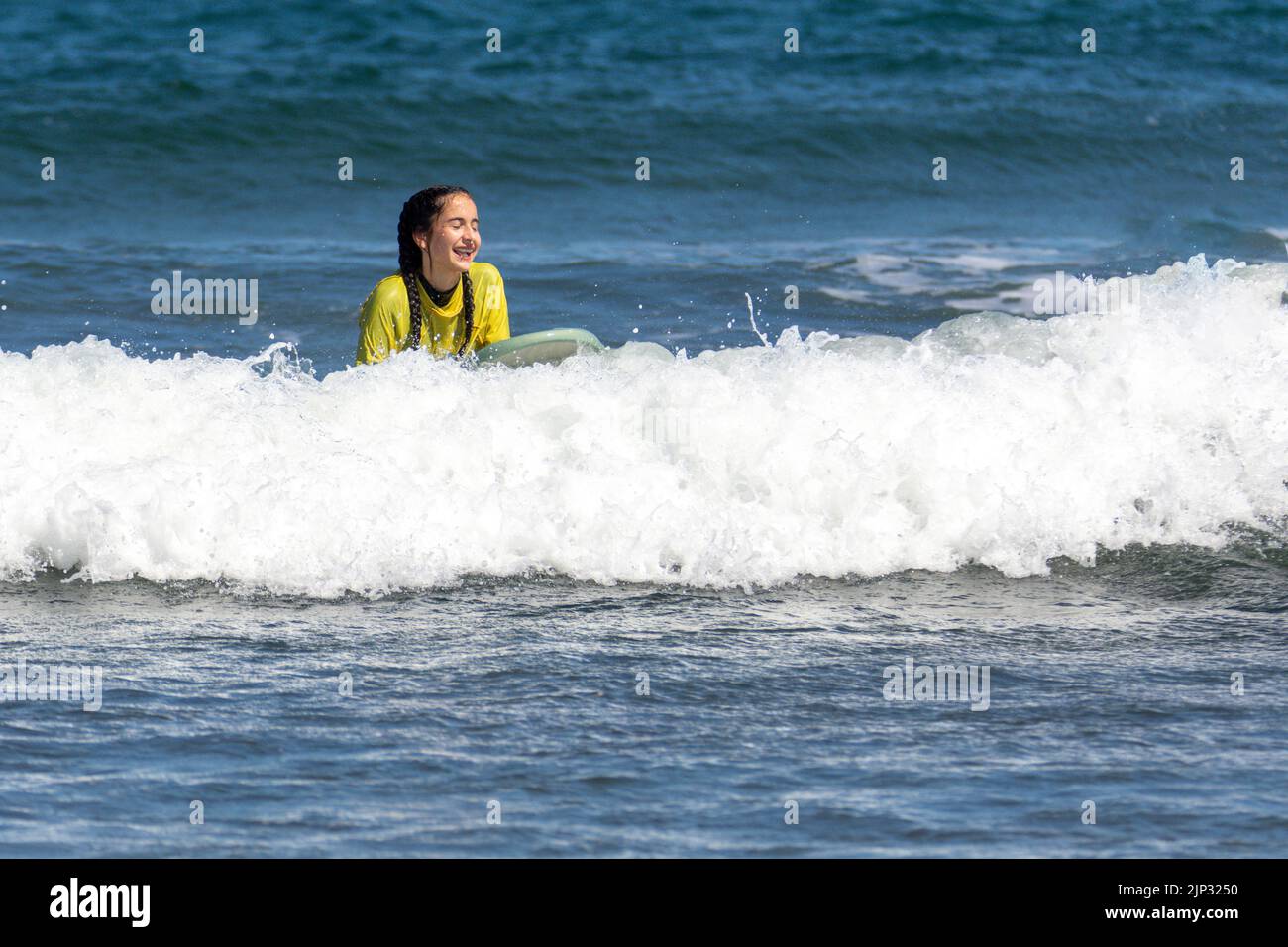 Donna sorridente e felice che naviga in mare in una parola di sole Foto Stock