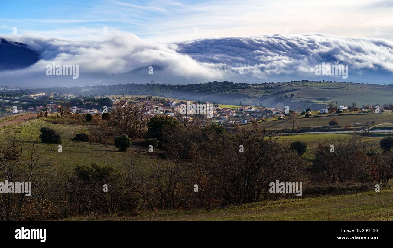 Nuvole di paesaggio e fitta nebbia scendendo la montagna verso terra in inverno. Somosierra, Spagna, Foto Stock
