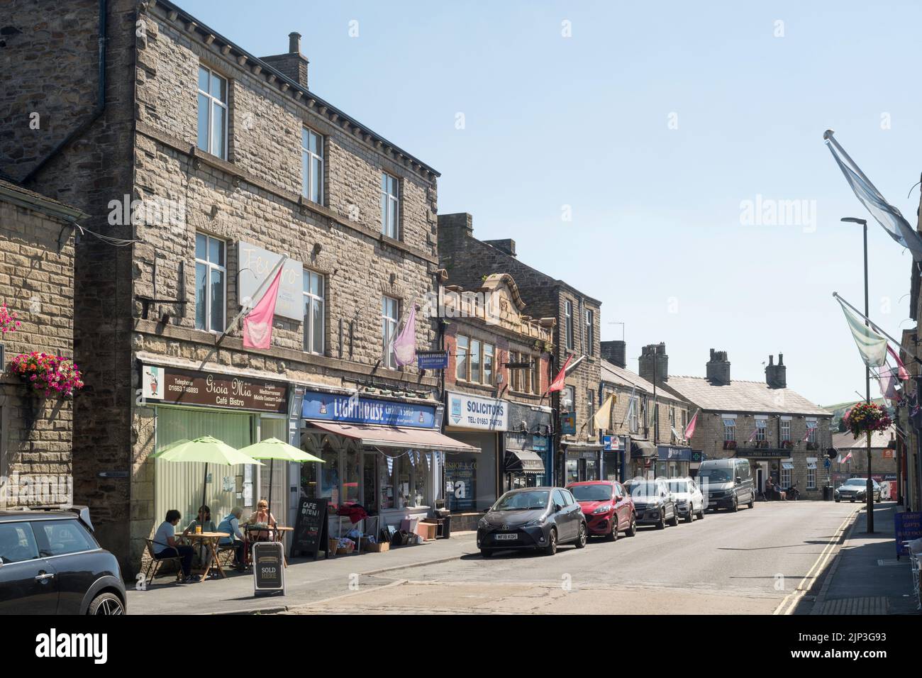La gente si sedette al di fuori del caffè di Market St, New Mills, Derbyshire, Inghilterra, Regno Unito Foto Stock