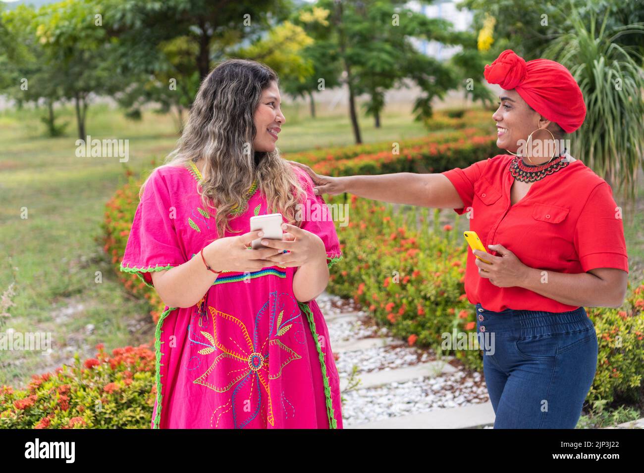 Due ragazze multietniche parlano nel parco cittadino Foto Stock