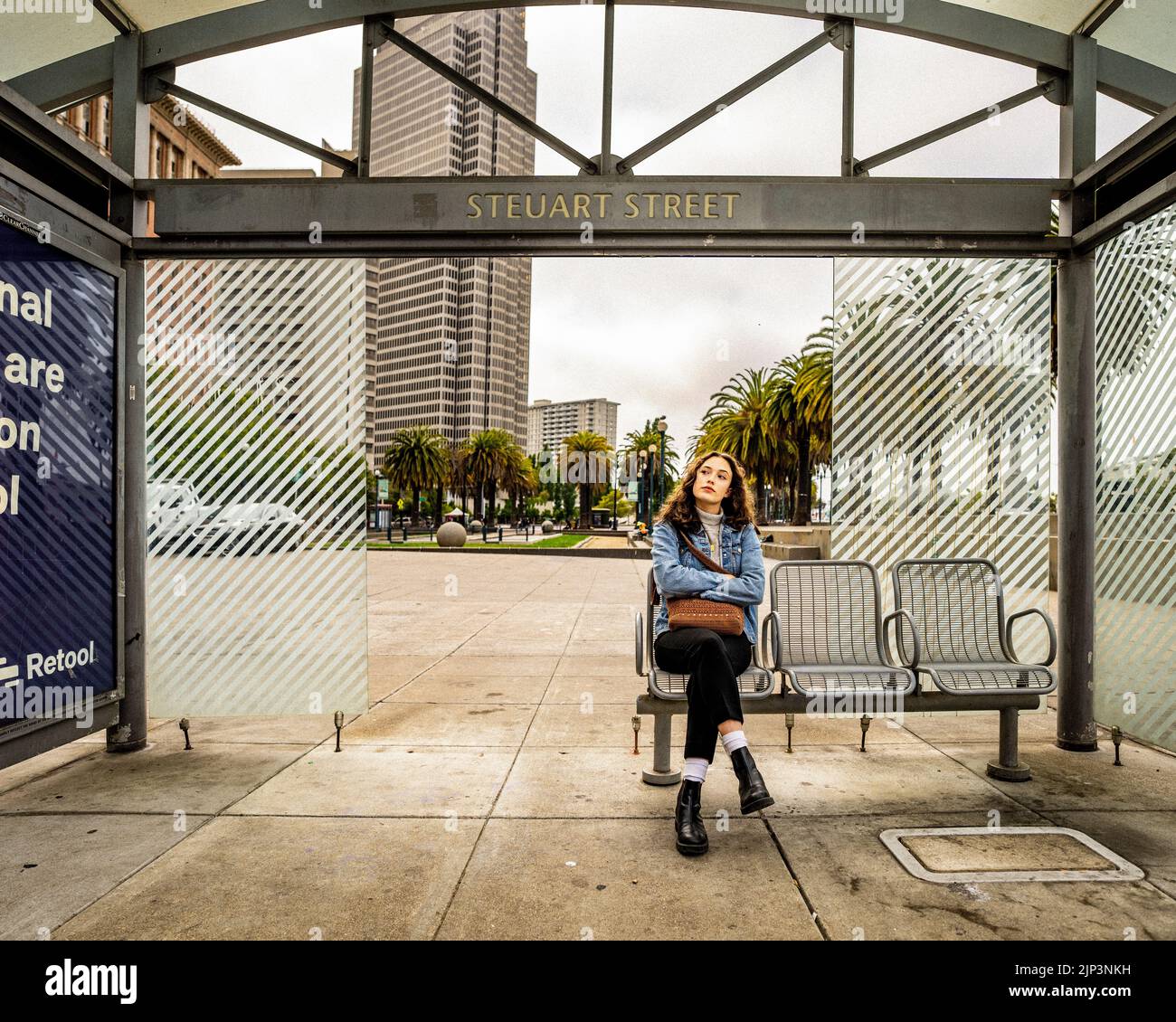 Ritratto senza posa di giovane donna in attesa di trasporti pubblici | San Francisco Muni Foto Stock