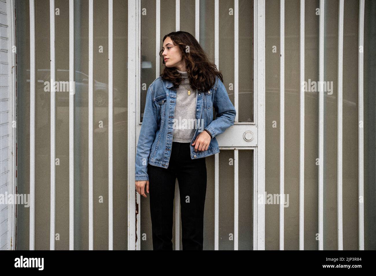 Ritratto senza posa della giovane donna in attesa di ferro porta di sicurezza | porta | Downtown marciapiede Foto Stock