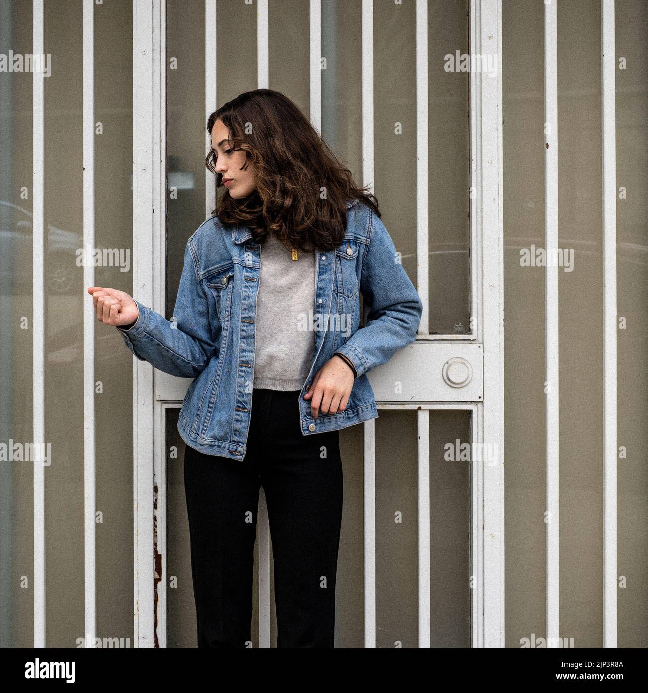 Ritratto senza posa della giovane donna in attesa di ferro porta di sicurezza | porta | Downtown marciapiede Foto Stock