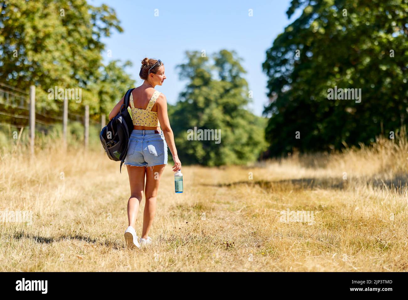 Donna che cammina all'aperto in campagna Foto Stock
