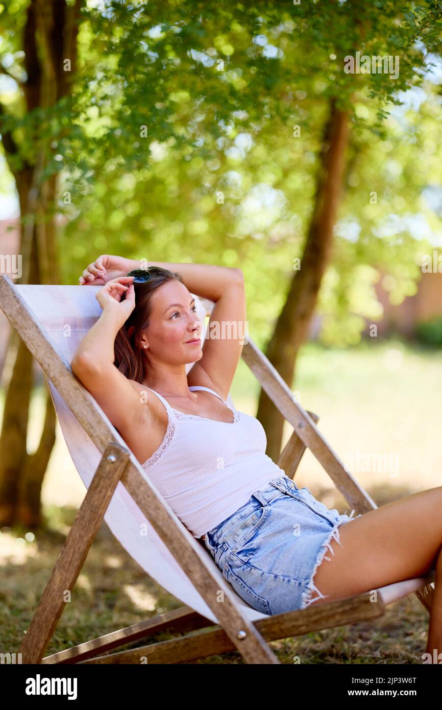 Attraente donna seduto rilassante all'aperto Foto Stock
