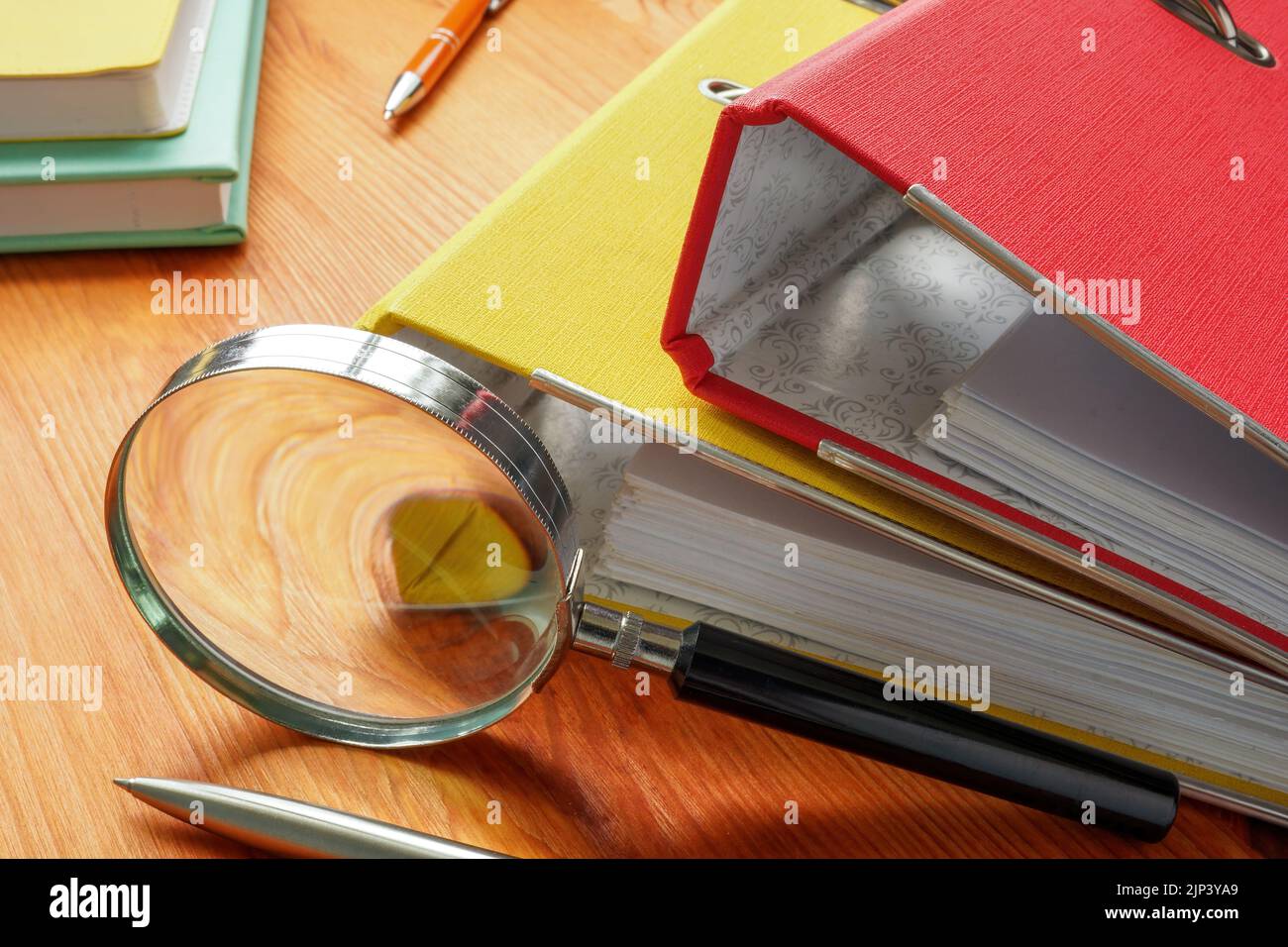 Concetto di indagine sul luogo di lavoro. Cartelle con carta e una lente di ingrandimento. Foto Stock