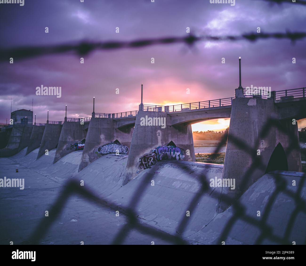 Un ponte di cemento con pareti di graffiti arti durante un bellissimo tramonto Foto Stock