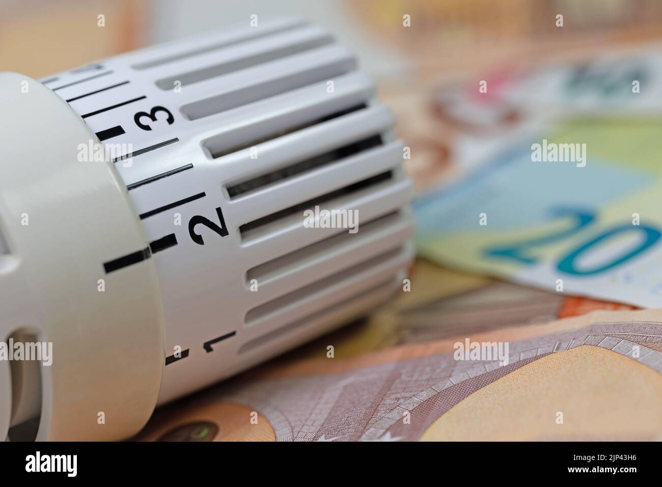 Termostato davanti alle banconote, simbolo dei costi di riscaldamento Foto Stock